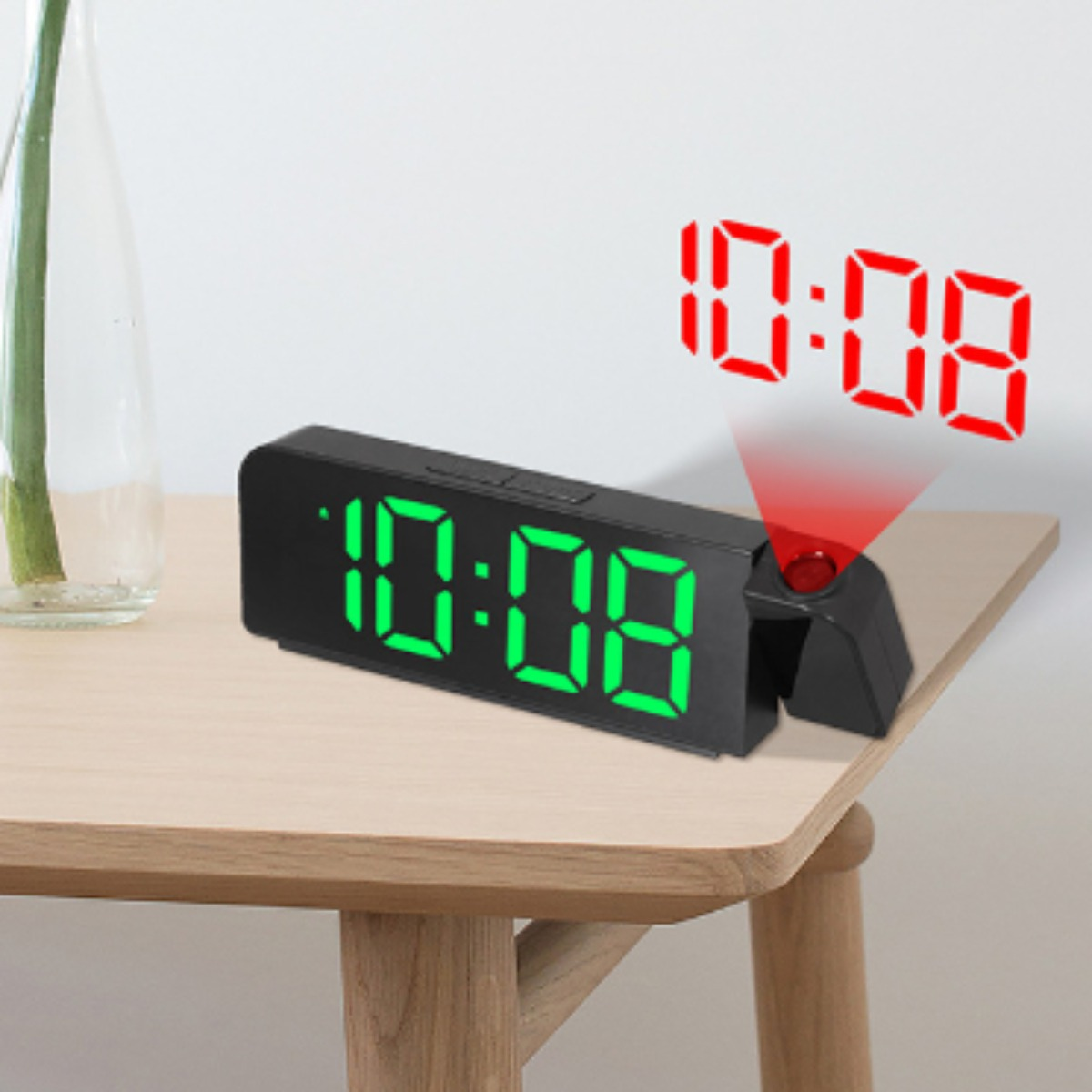 Digitaluhr zeigt 10:08. Die Zeit wird rot projiziert. Die Uhr steht auf einem Holztisch.