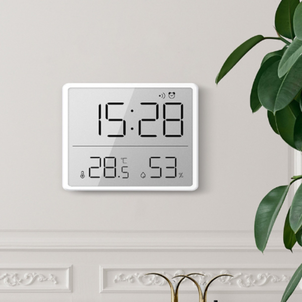 Digitaluhr mit Anzeige von Zeit, Temperatur und Luftfeuchtigkeit. Weißer Rahmen, an der Wand befestigt.