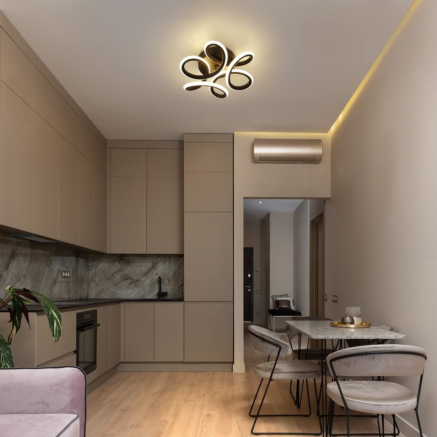 Nowoczesna kuchnia wyposażona jest w szafki w kolorze opalenizny, marmurowy panel ścienny i czarno-złotą lampę sufitową.