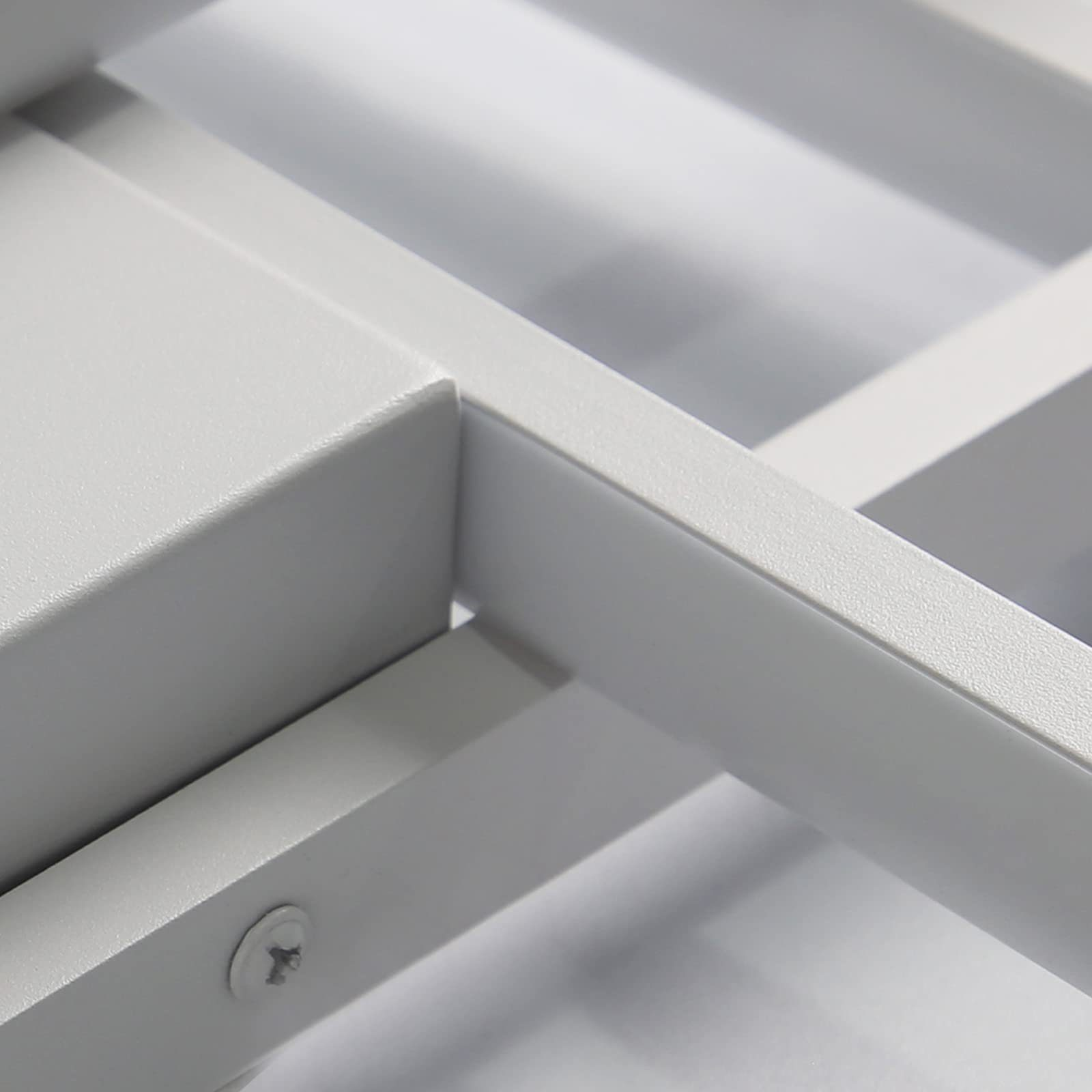 Zbliżenie jasnoszarej metalowej ramy z widoczną śrubą.