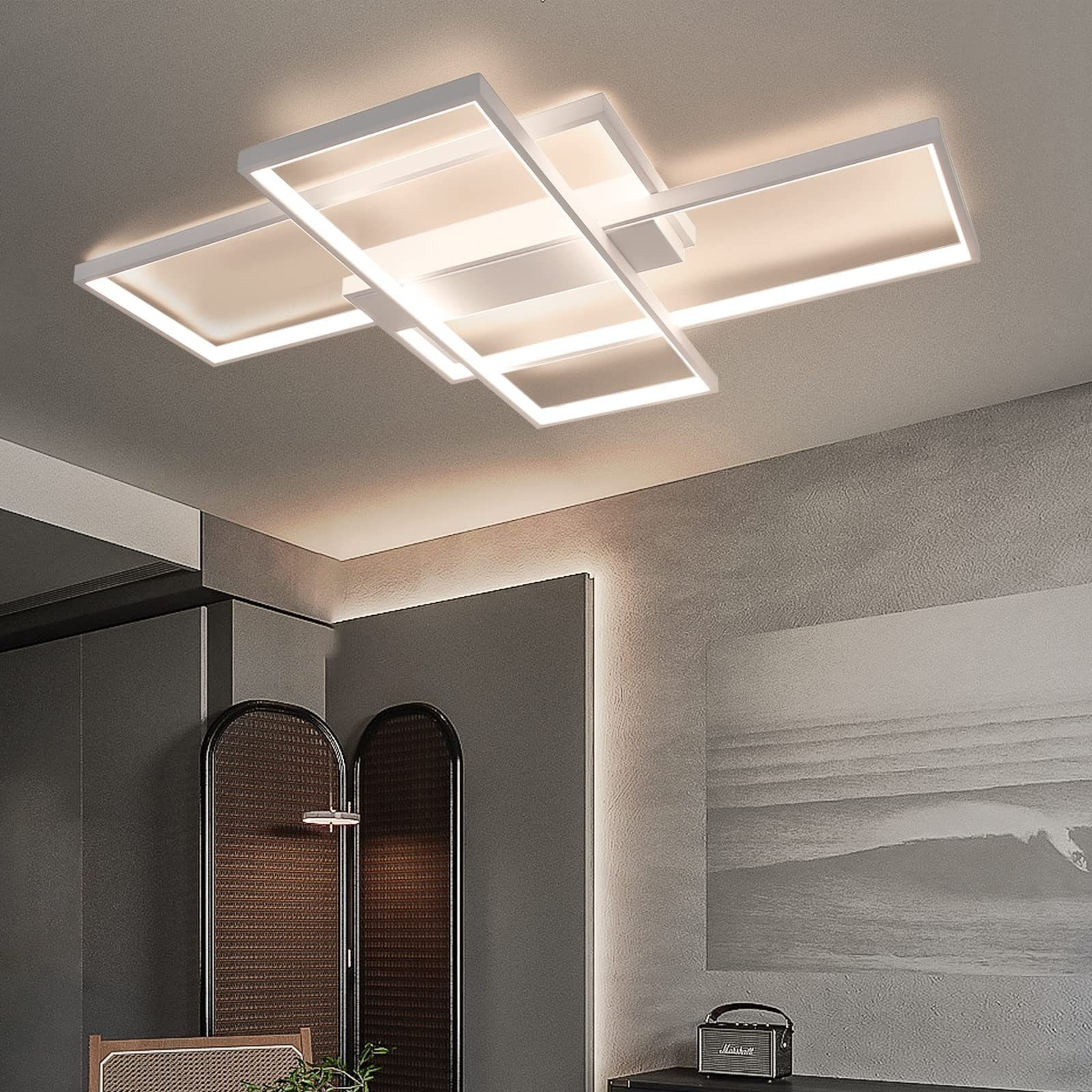 Nowoczesna biała lampa sufitowa z nakładającymi się prostokątnymi panelami, w pokoju z szarymi ścianami.