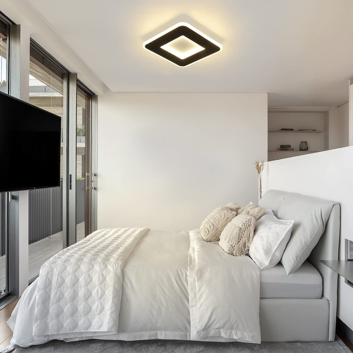 Dormitorio moderno con una luz de techo cuadrada, cama y ventanas grandes, creando un espacio brillante.