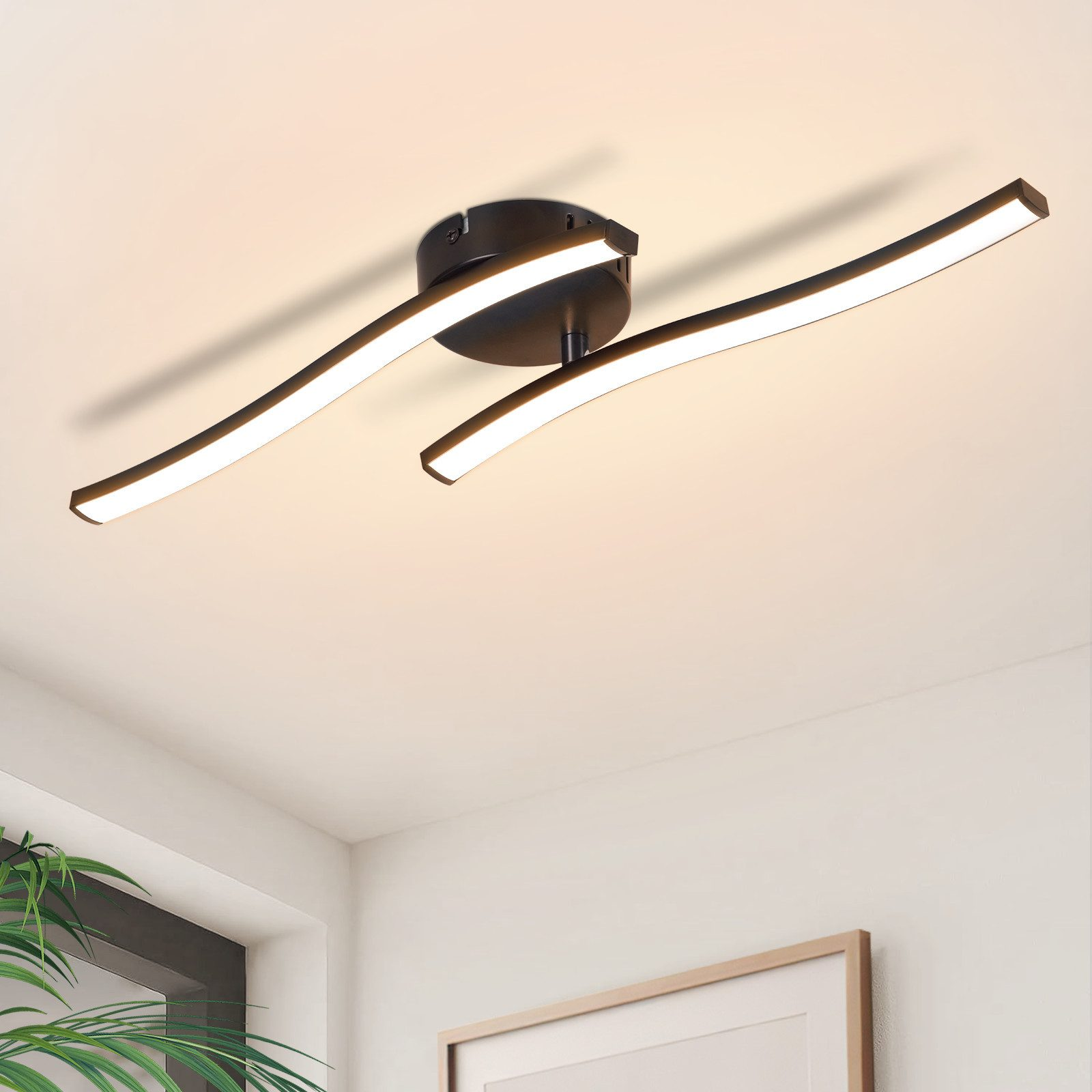 Lampada da soffitto con due barre curve illuminate, montata su un soffitto bianco.