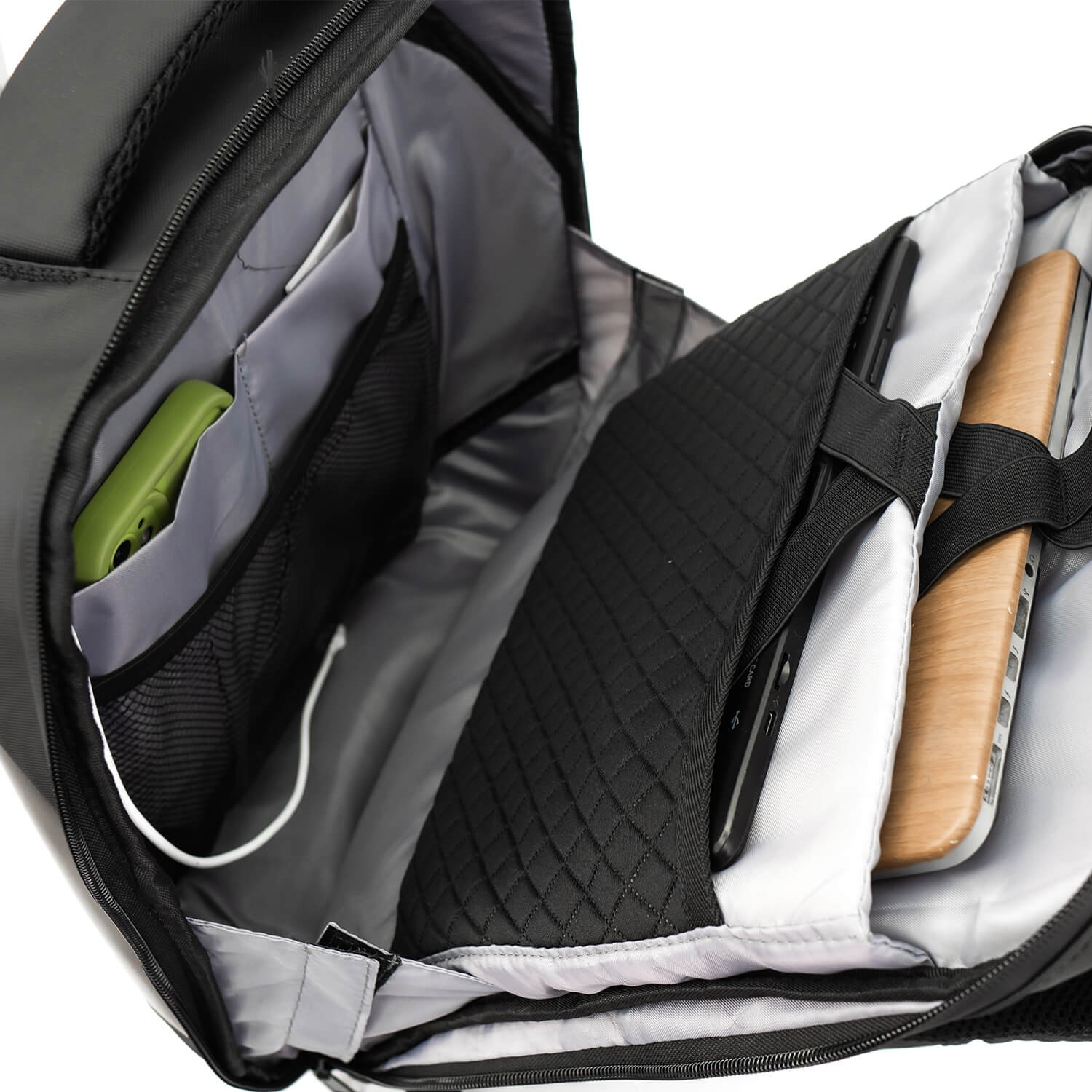 Mochila negra abierta con compartimentos, incluyendo un portátil y objetos.