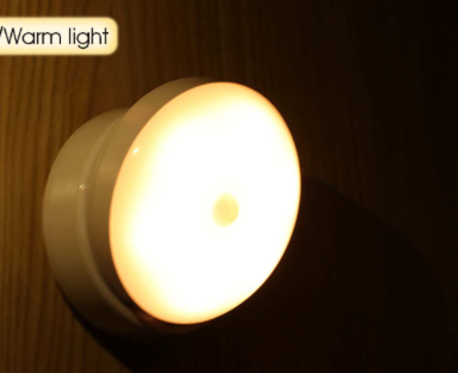 Ein rundes Nachtlicht mit warmem Licht wird vor einem dunklen Hintergrund angezeigt.