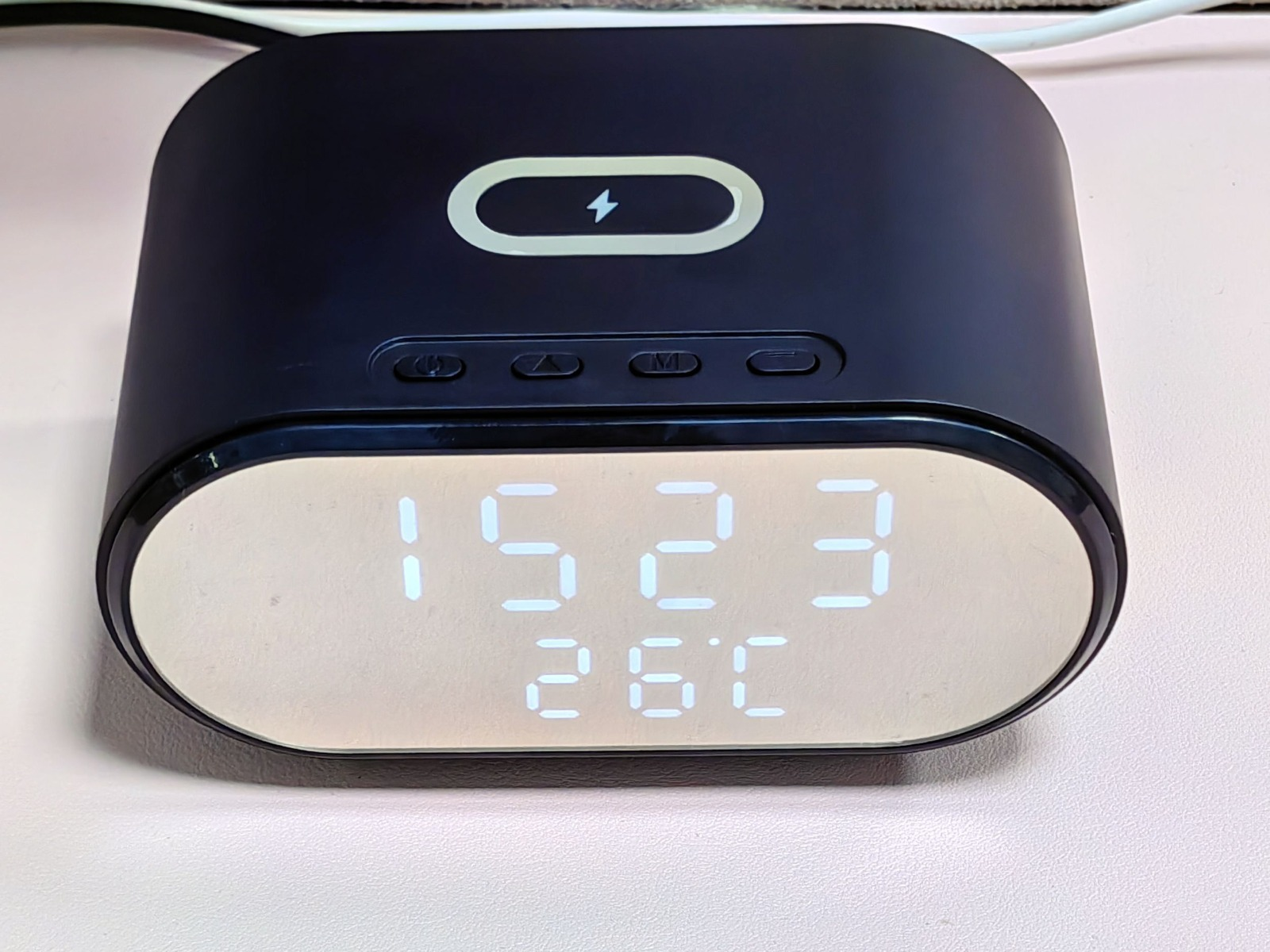 Schwarzer digitaler Wecker mit Anzeige von Zeit und Temperatur. Der Wecker hat ein schwarzes Gehäuse.