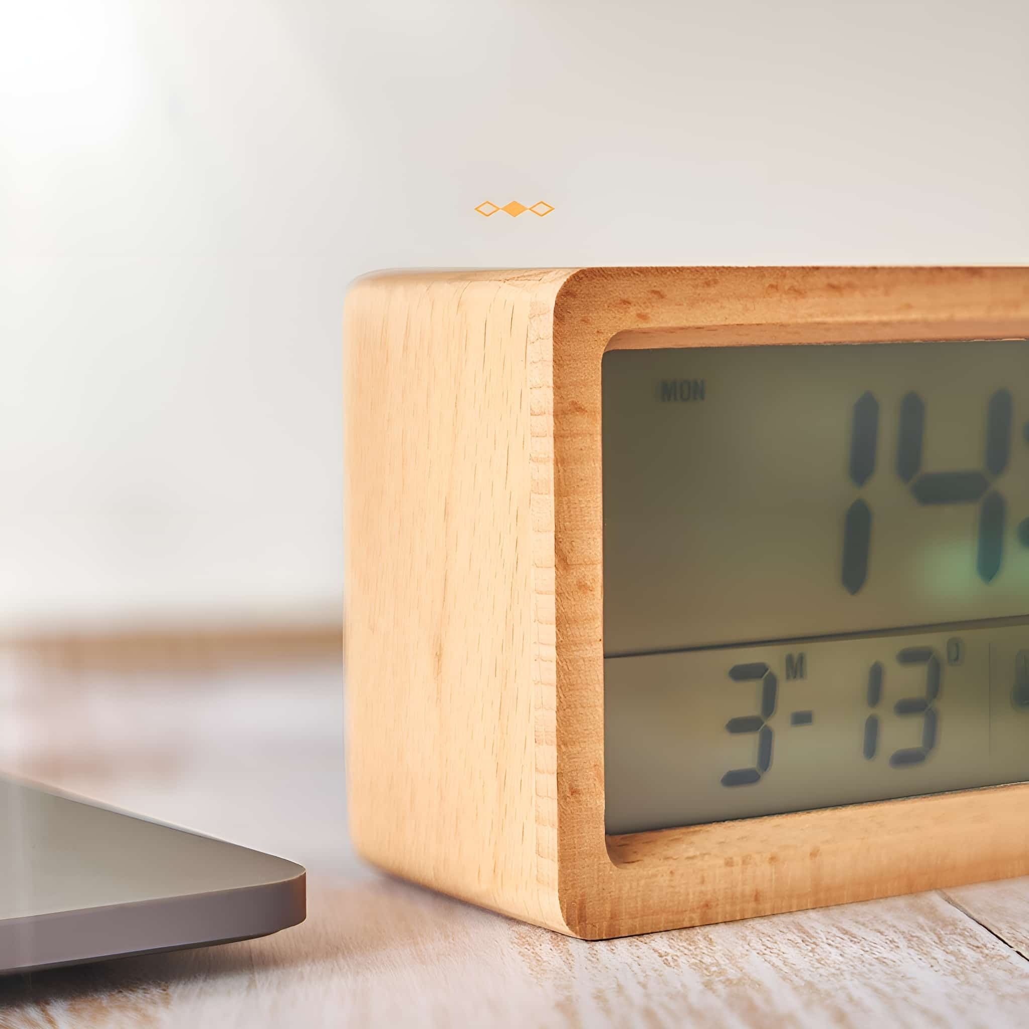 Digitaluhr aus Holz, zeigt Zeit und Temperatur mit verschwommenem Hintergrund. Zwei Diamanten.