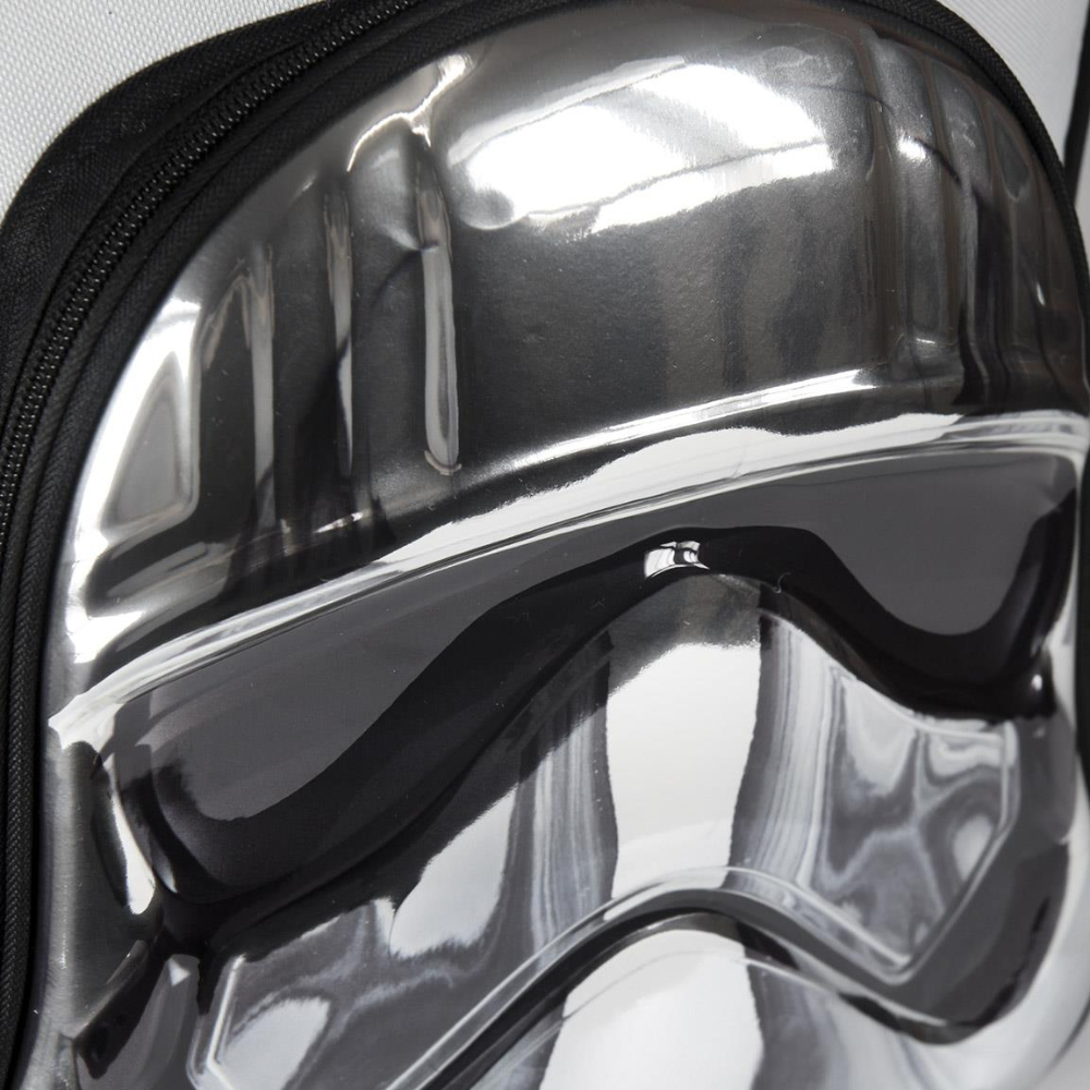 Primer plano de un casco de Stormtrooper en una mochila. Visera negra, detalles plateados. Cremallera negra. Fondo blanco.