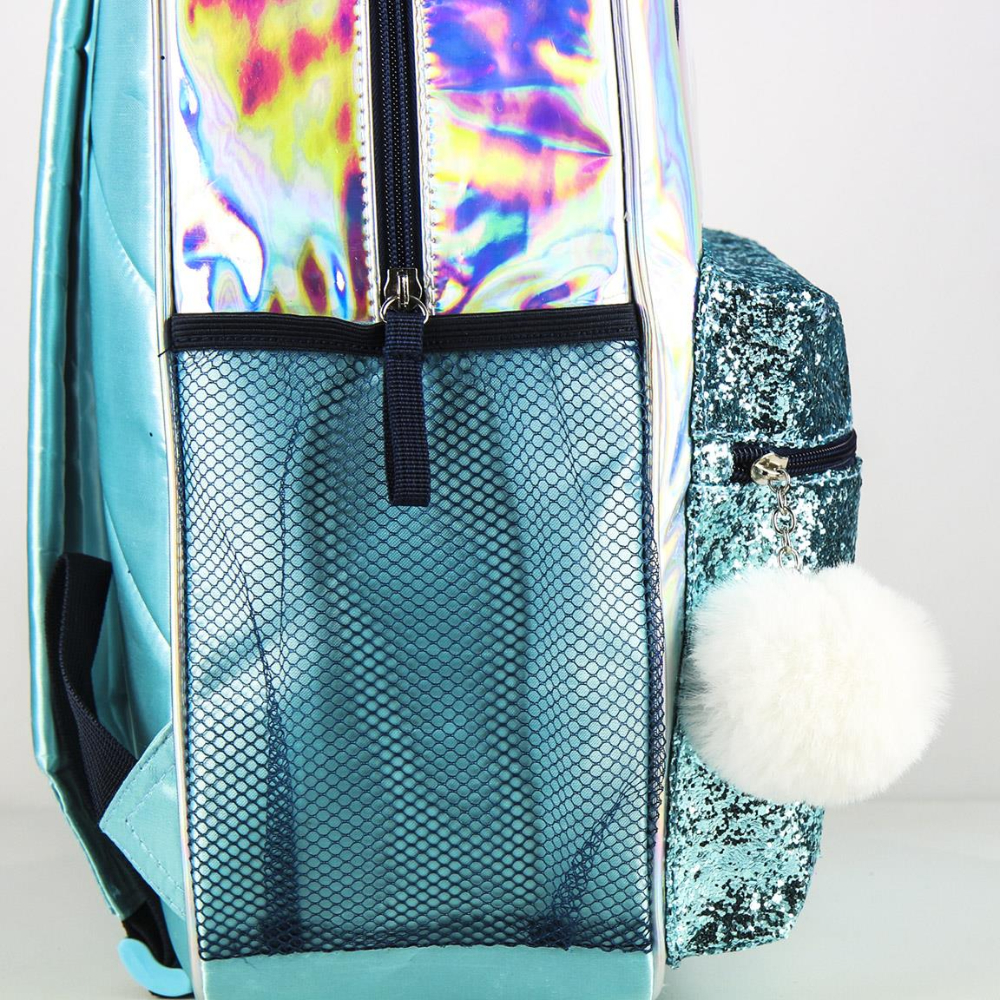 Vista lateral de una mochila azul con bolsillo de malla y pompón. Fondo blanco.