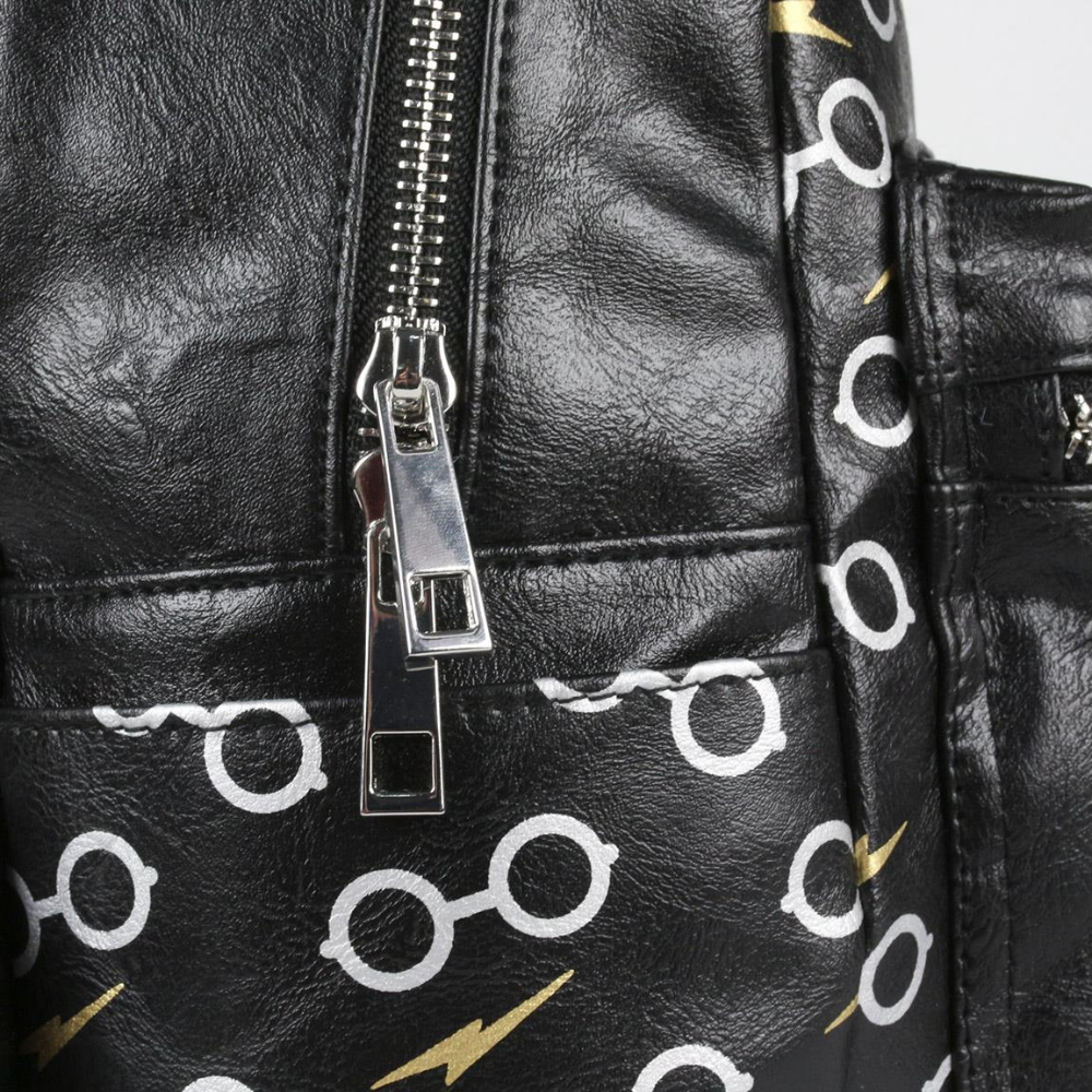 Primer plano de mochila negra con patrón de gafas y cremallera. Fondo blanco.