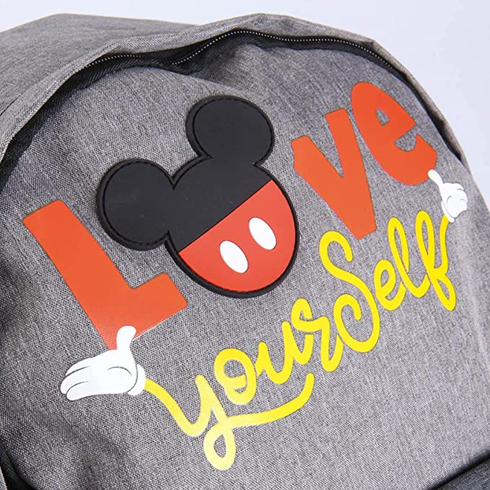 Mochila gris con el logo de Mickey Mouse. Las palabras 'LOVE yourself' en naranja y amarillo.