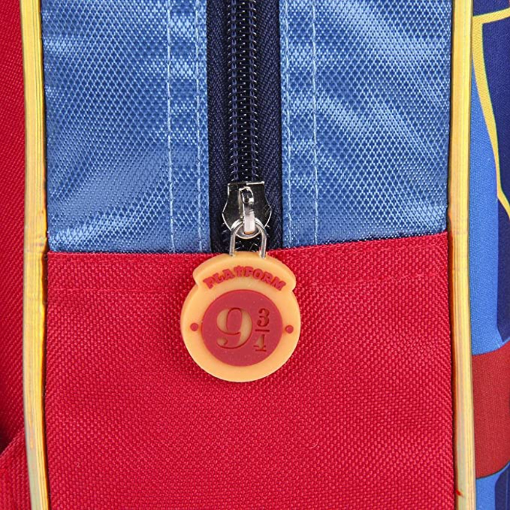 Primer plano de la cremallera de una mochila roja y azul, con etiqueta de Plataforma 9 3/4.