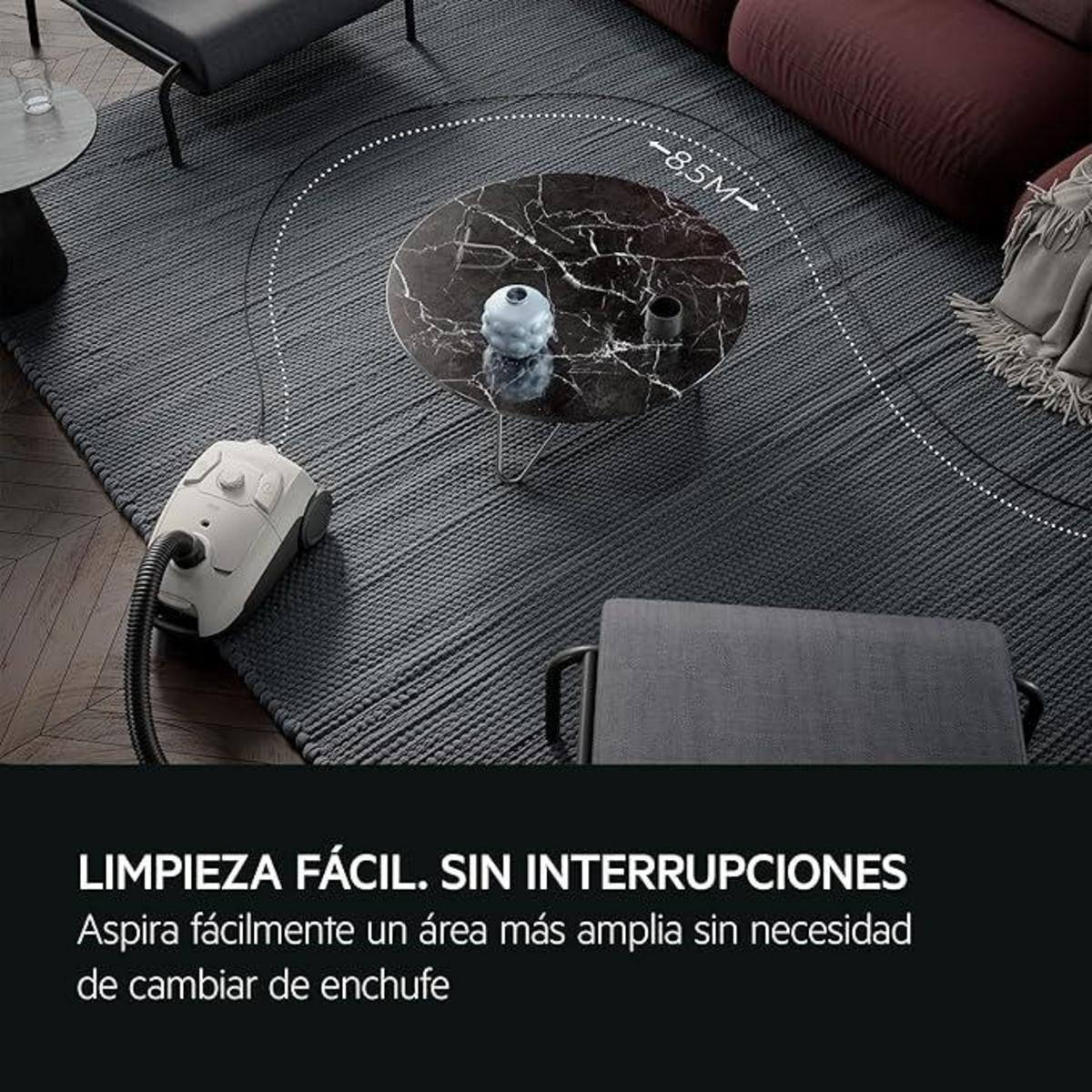 Aspiradora en una alfombra, con texto sobre limpieza. Salón con muebles.
