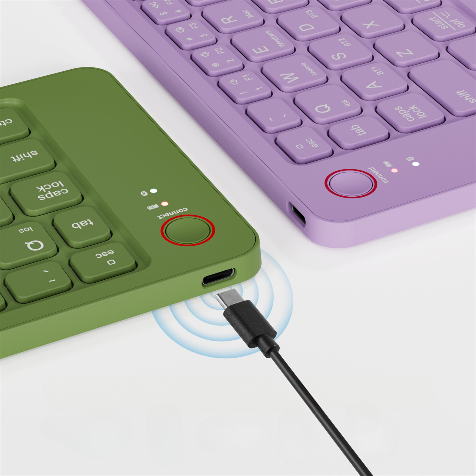 Zwei Tastaturen, eine grüne und eine lila, verbunden mit einem USB-C-Kabel.