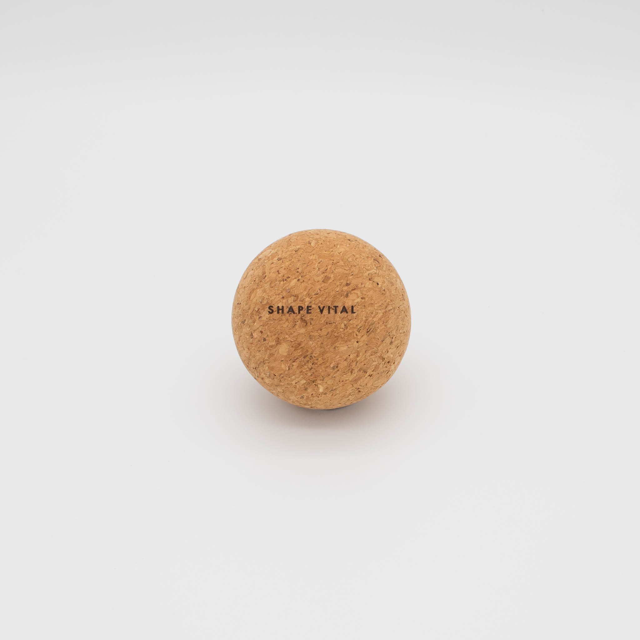 Ein brauner Korkball mit der Aufschrift 'SHAPE VITAL' auf weißem Hintergrund.