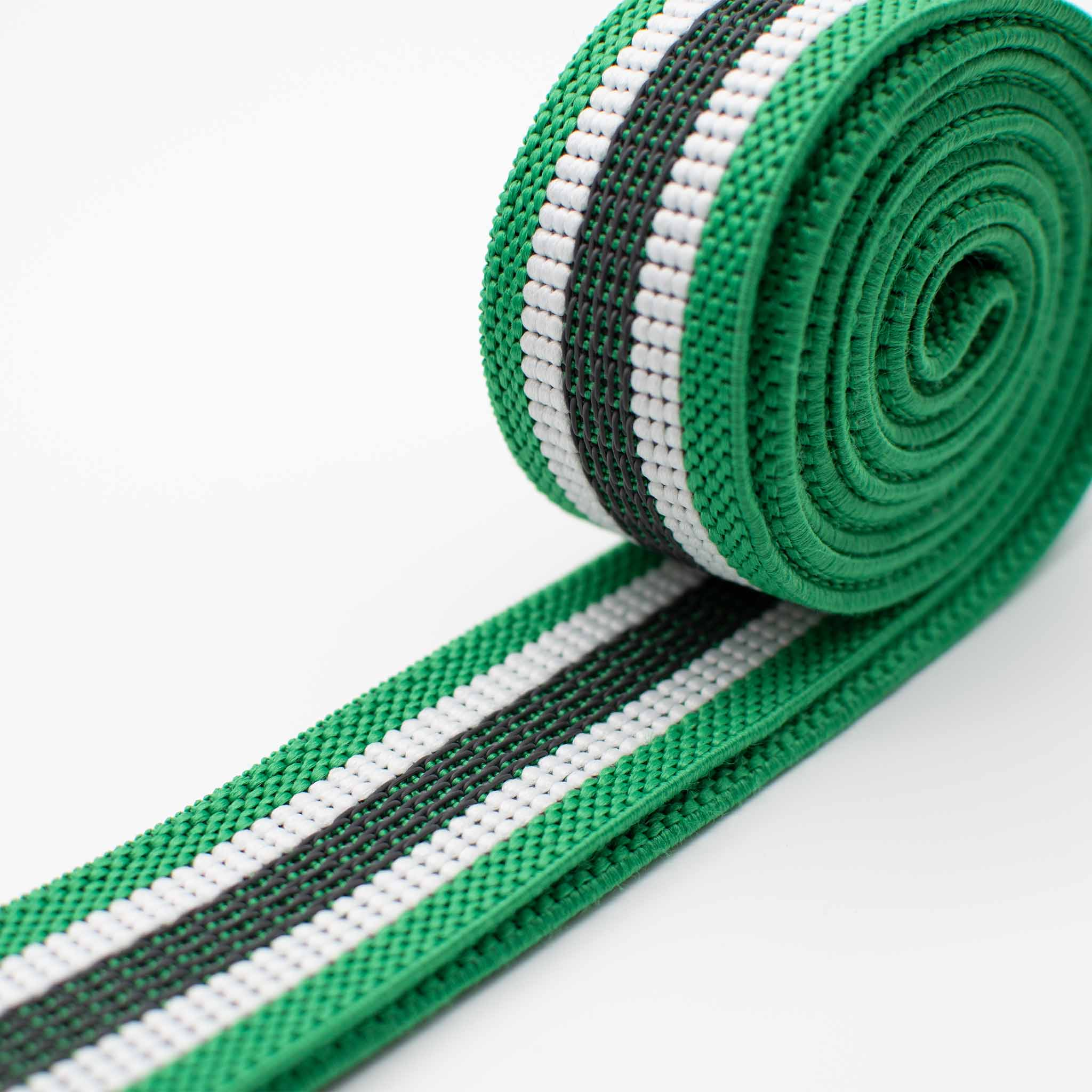 Grünes, weißes und schwarz gestreiftes Gummiband, aufgerollt auf weißem Hintergrund.