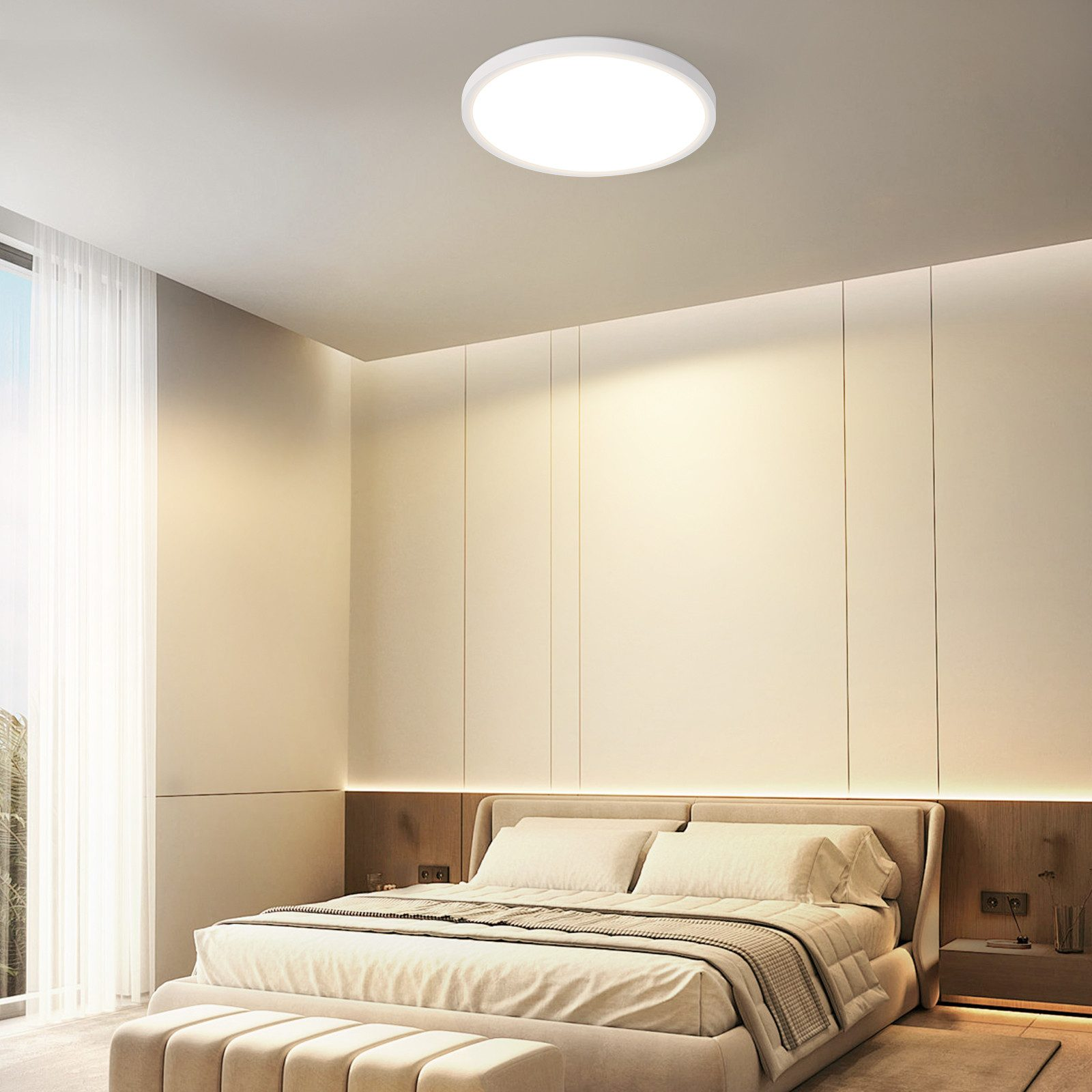 Ein modernes Schlafzimmer mit Bett, neutralen Tönen, großem Fenster und kreisförmiger Deckenleuchte.