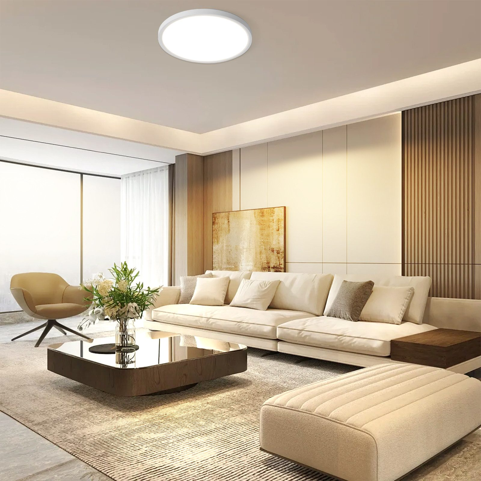 Un salón moderno con un sofá blanco, mesa de centro y luz de techo redonda. Los colores neutros dominan la escena.
