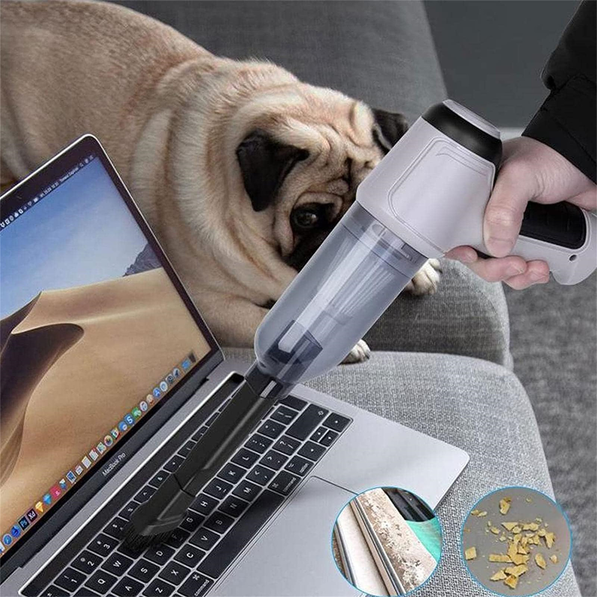 Eine Person benutzt einen Handstaubsauger auf einer Laptop-Tastatur, im Hintergrund ein Mops.