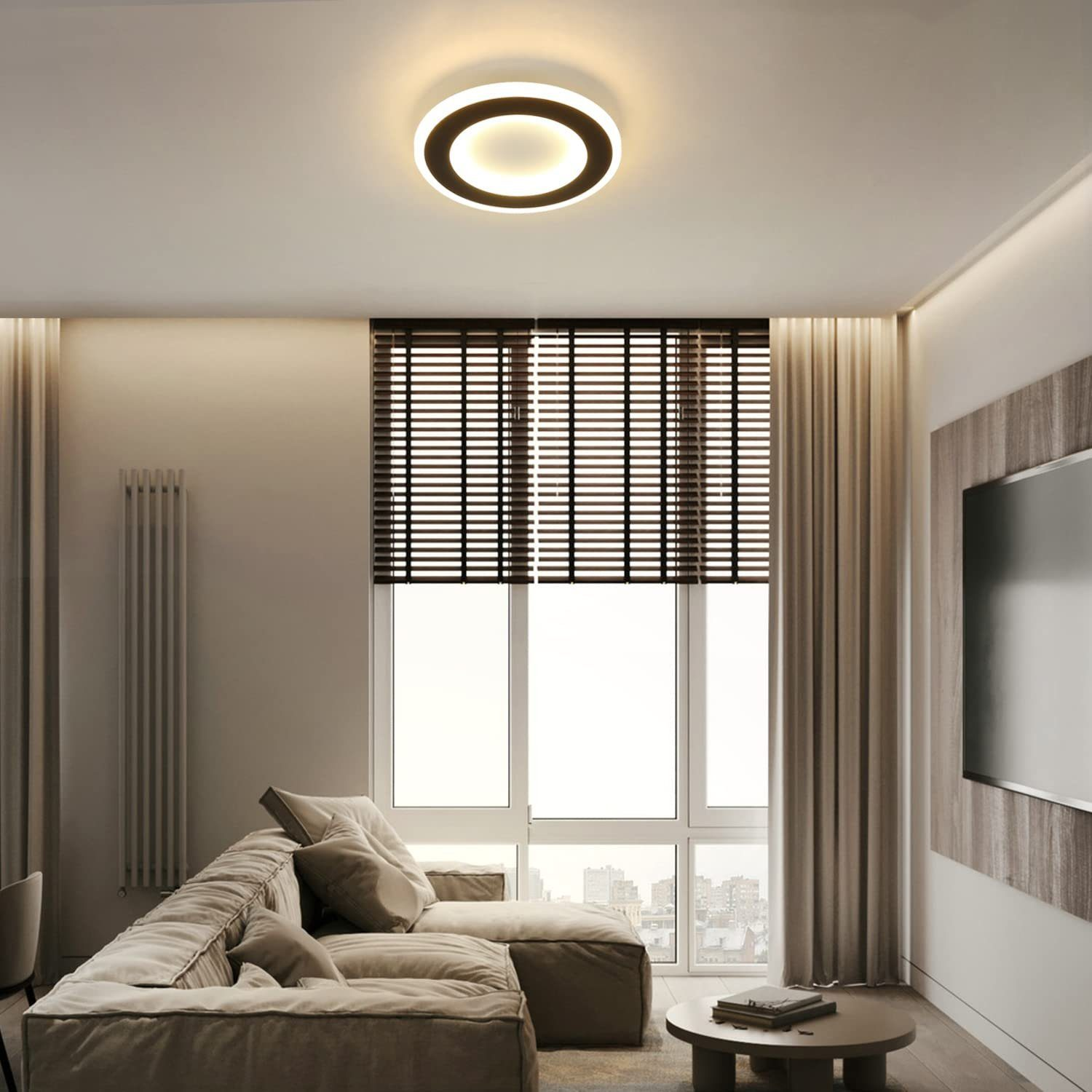 Salón con sofá beige, ventana con persianas y luz de techo redonda.