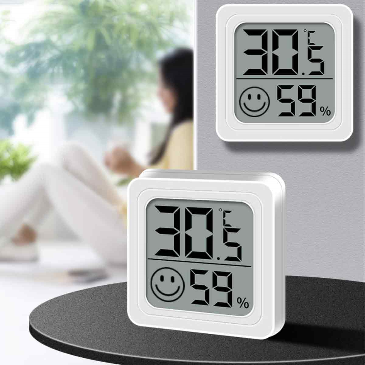 Zwei kleine digitale Thermometer, die Temperatur- und Feuchtigkeitsmesswerte anzeigen.