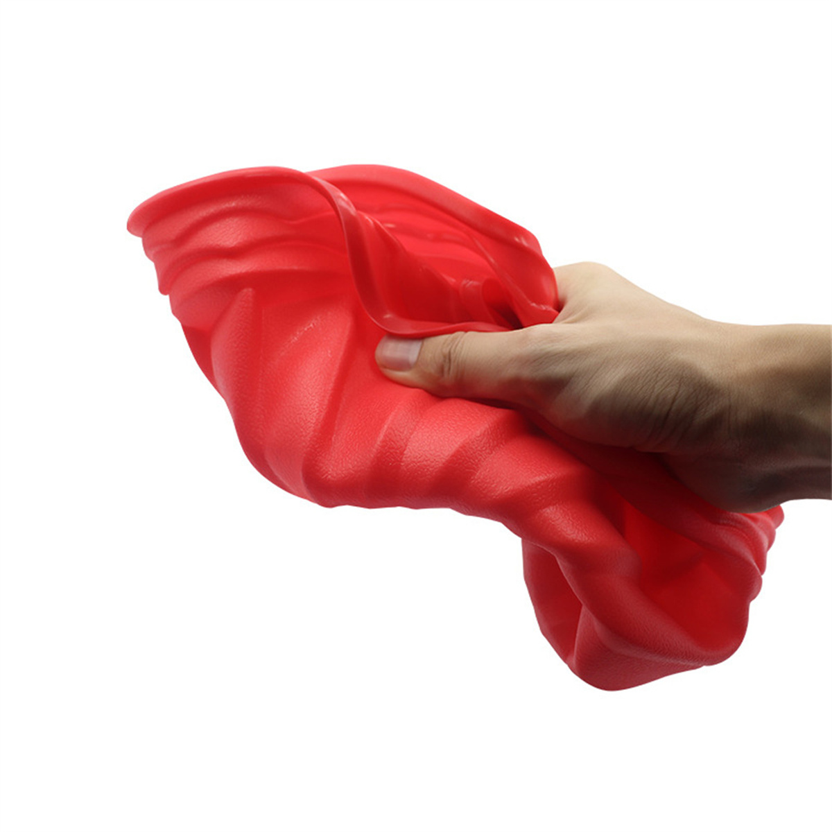 Hand, die ein rotes, gefaltetes, gummiartiges Objekt hält. Das Objekt ist strukturiert und flexibel.