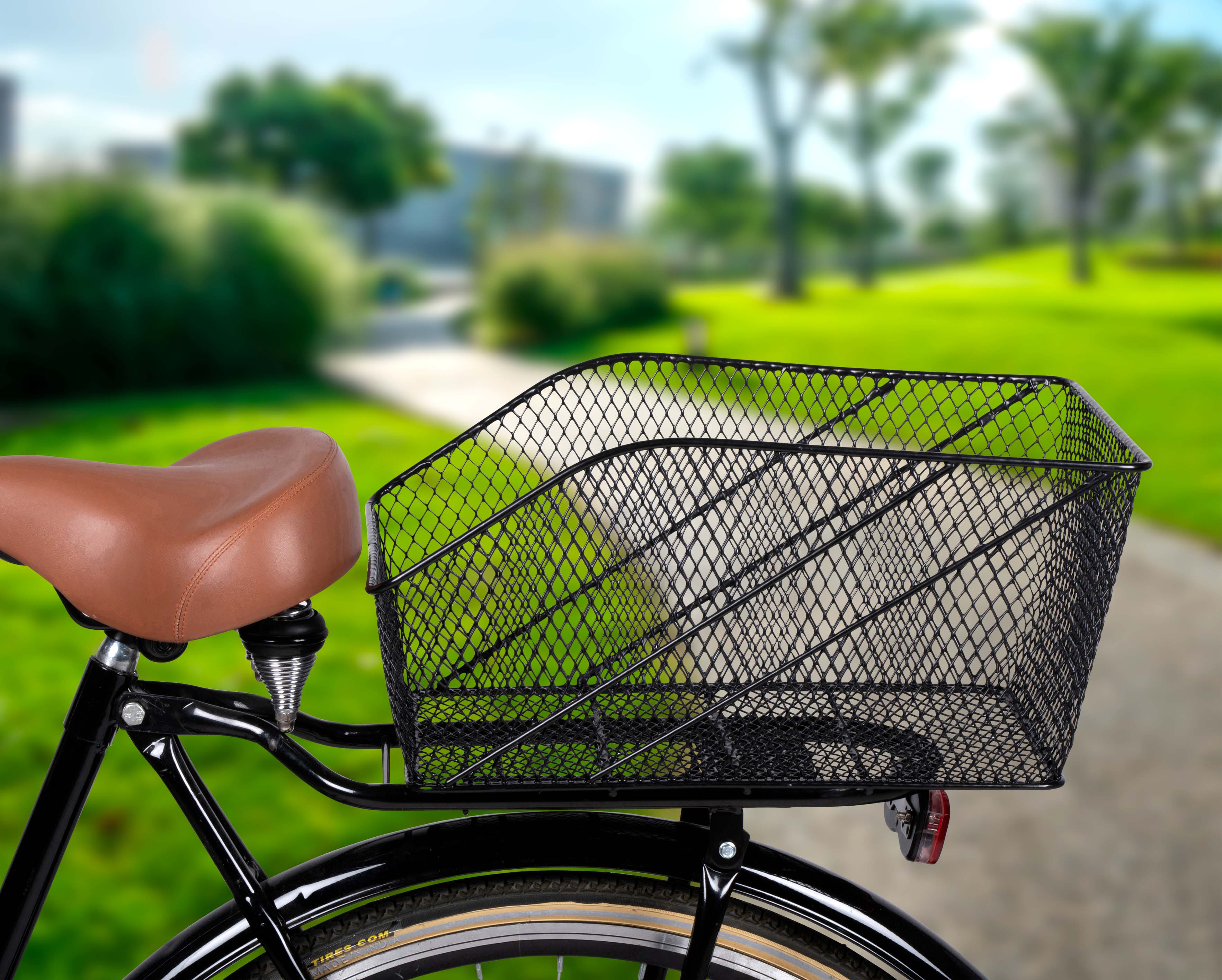 Fiets met een zwarte draadmand, in een parkomgeving.