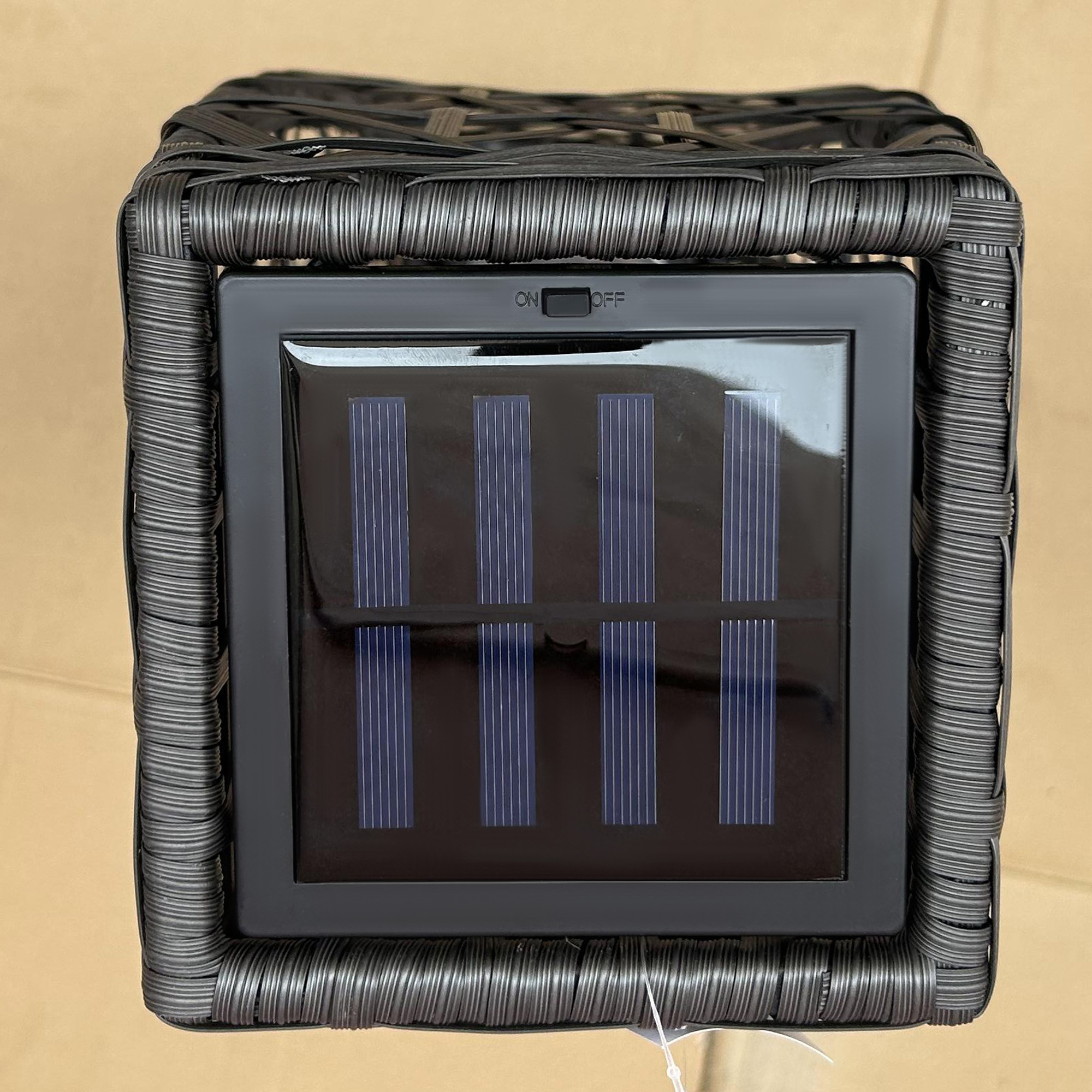 Schwarzer gewebter Würfel mit Solarpanel. Dunkler Hintergrund.
