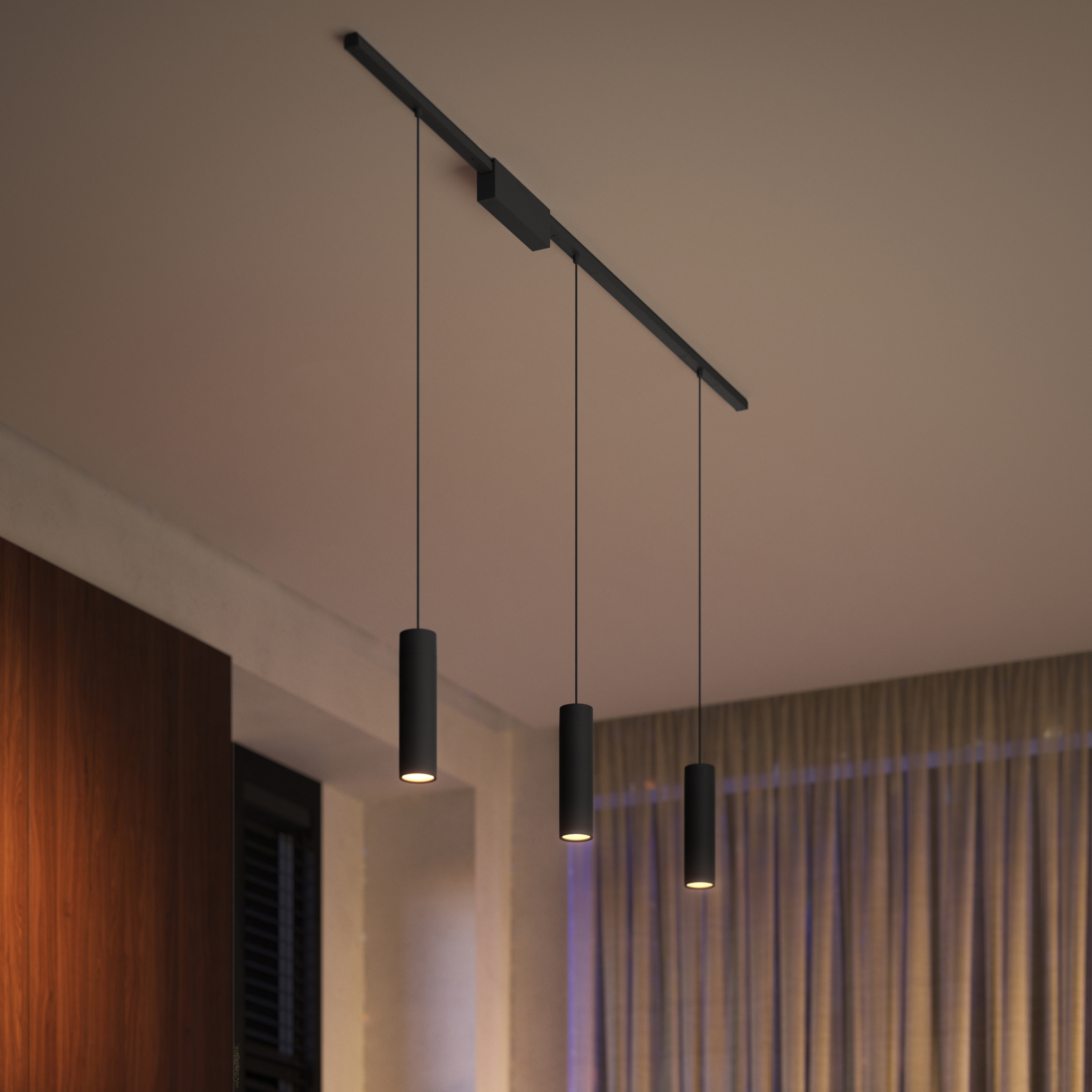 Trzy czarne, cylindryczne lampy wiszące zwisają z sufitu. Ciepłe światło.