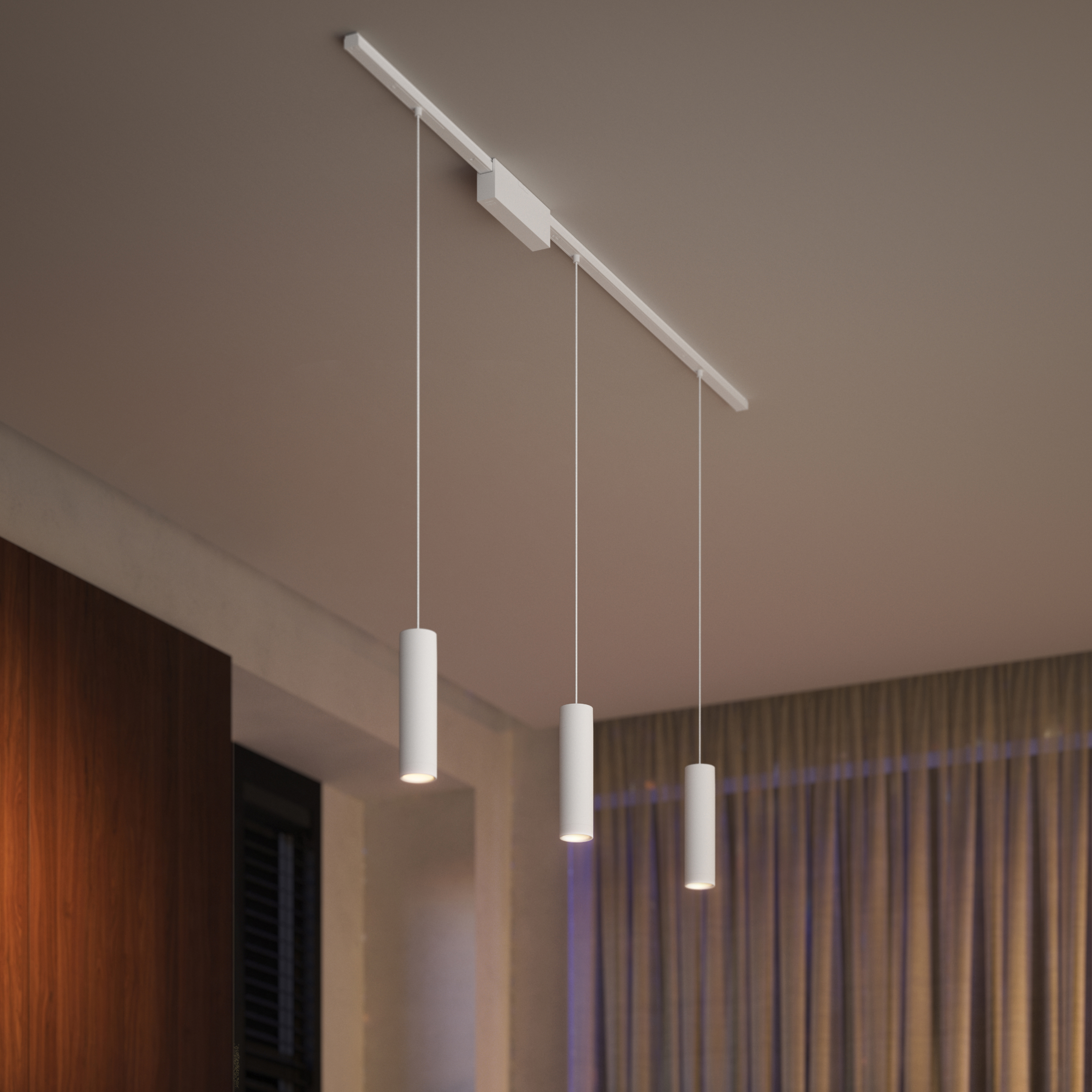 Trzy białe, cylindryczne lampy wiszące z szyny sufitowej.