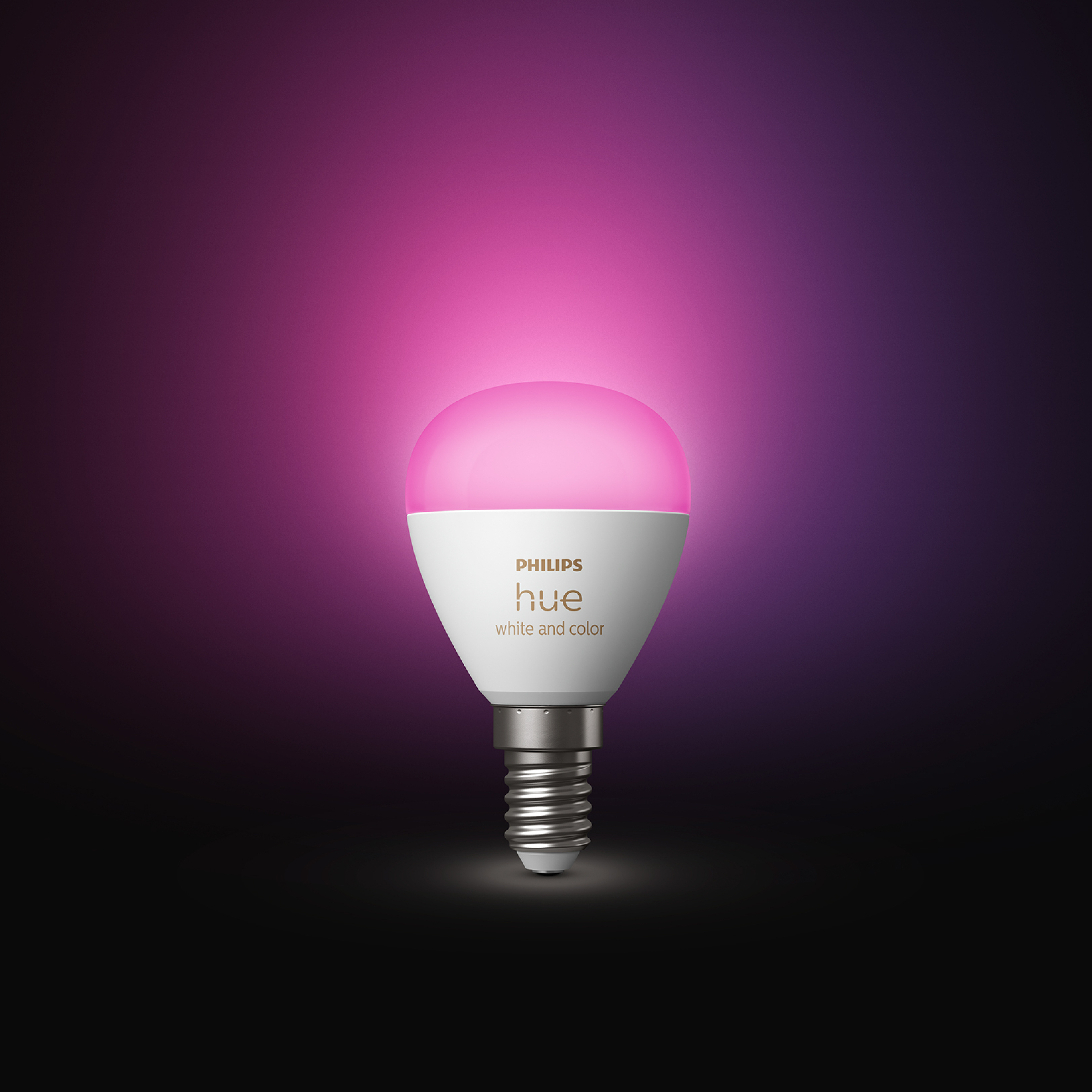 Inteligentna żarówka Philips Hue, biała i kolorowa, z różową poświatą. Żarówka jest na ciemnym tle.