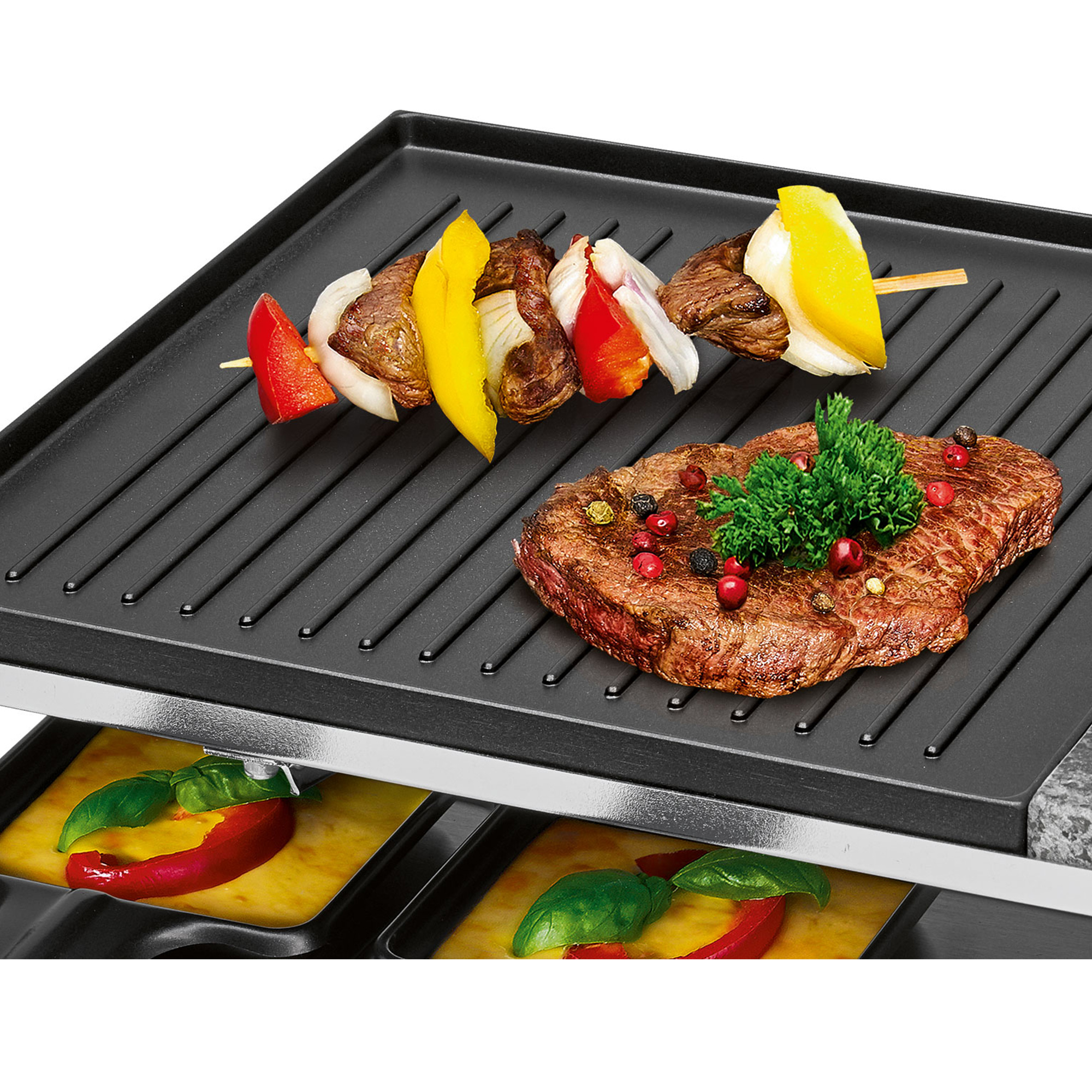 Jedzenie grillowane na czarnej powierzchni. Szaszłyki i stek z warzywami są pokazane.