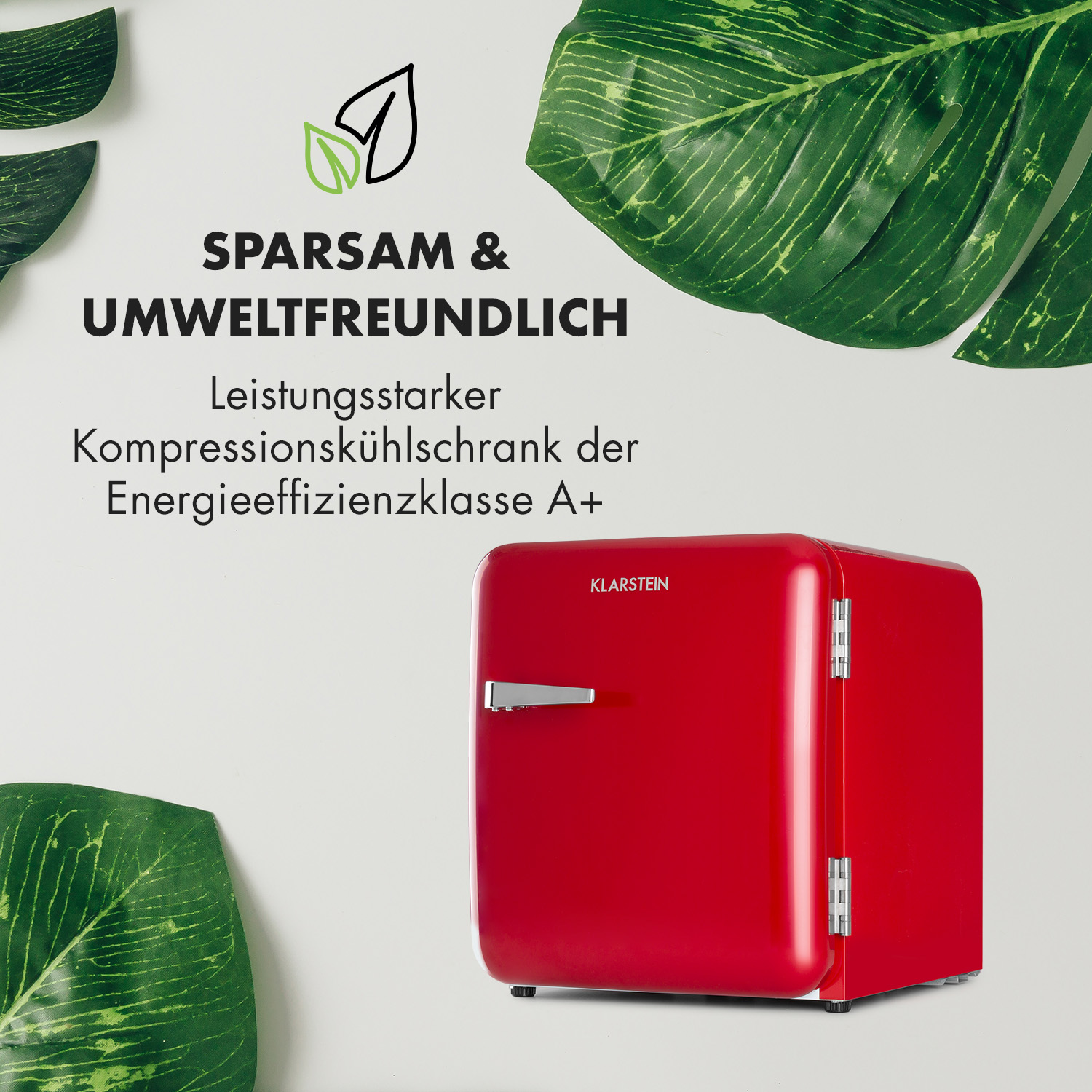 Mini frigo rosso con la scritta 'SPARSAM & UMWELTFREUNDLICH' e foglie verdi.