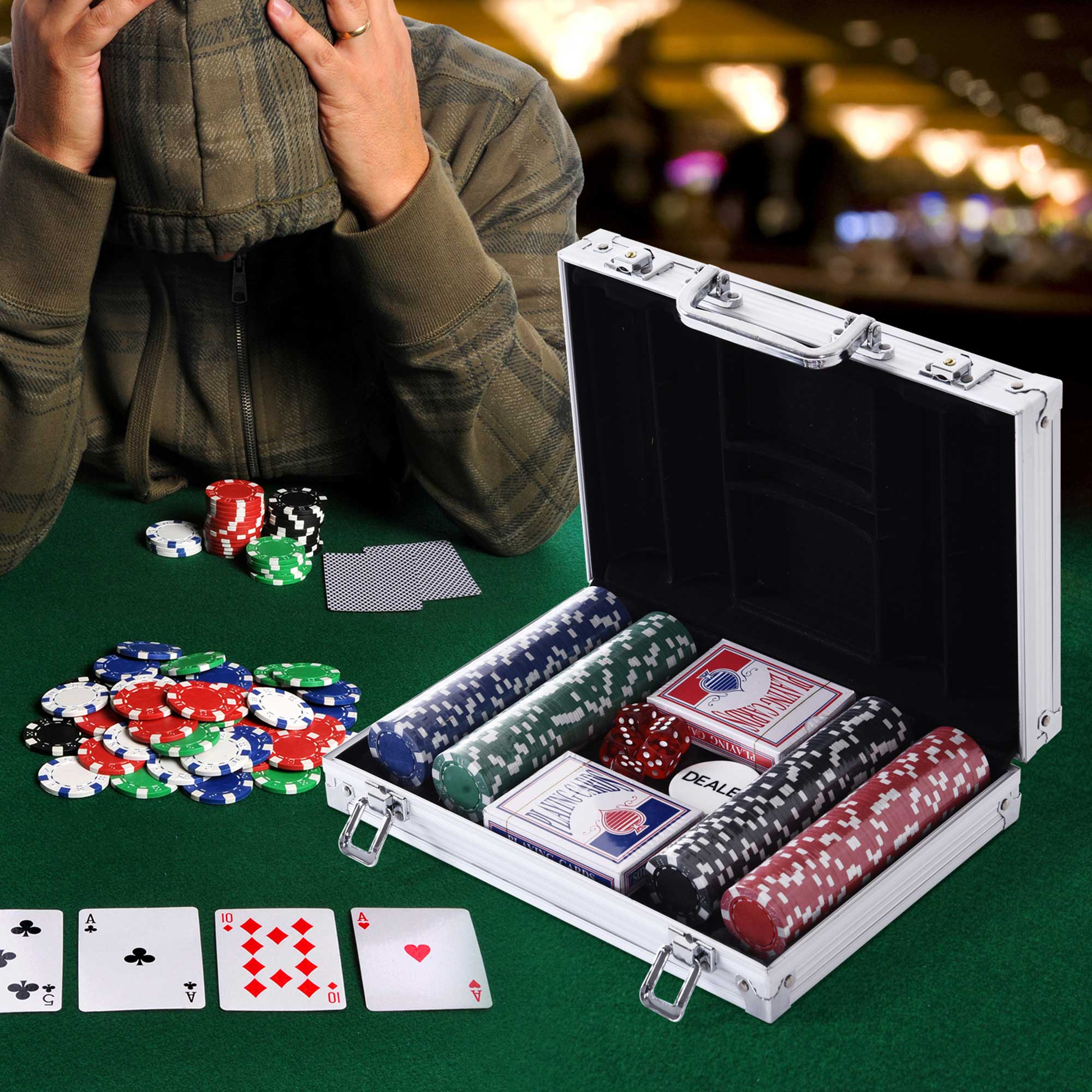 Una persona a un tavolo da poker. Fiches da poker, carte e una valigetta sul feltro verde.
