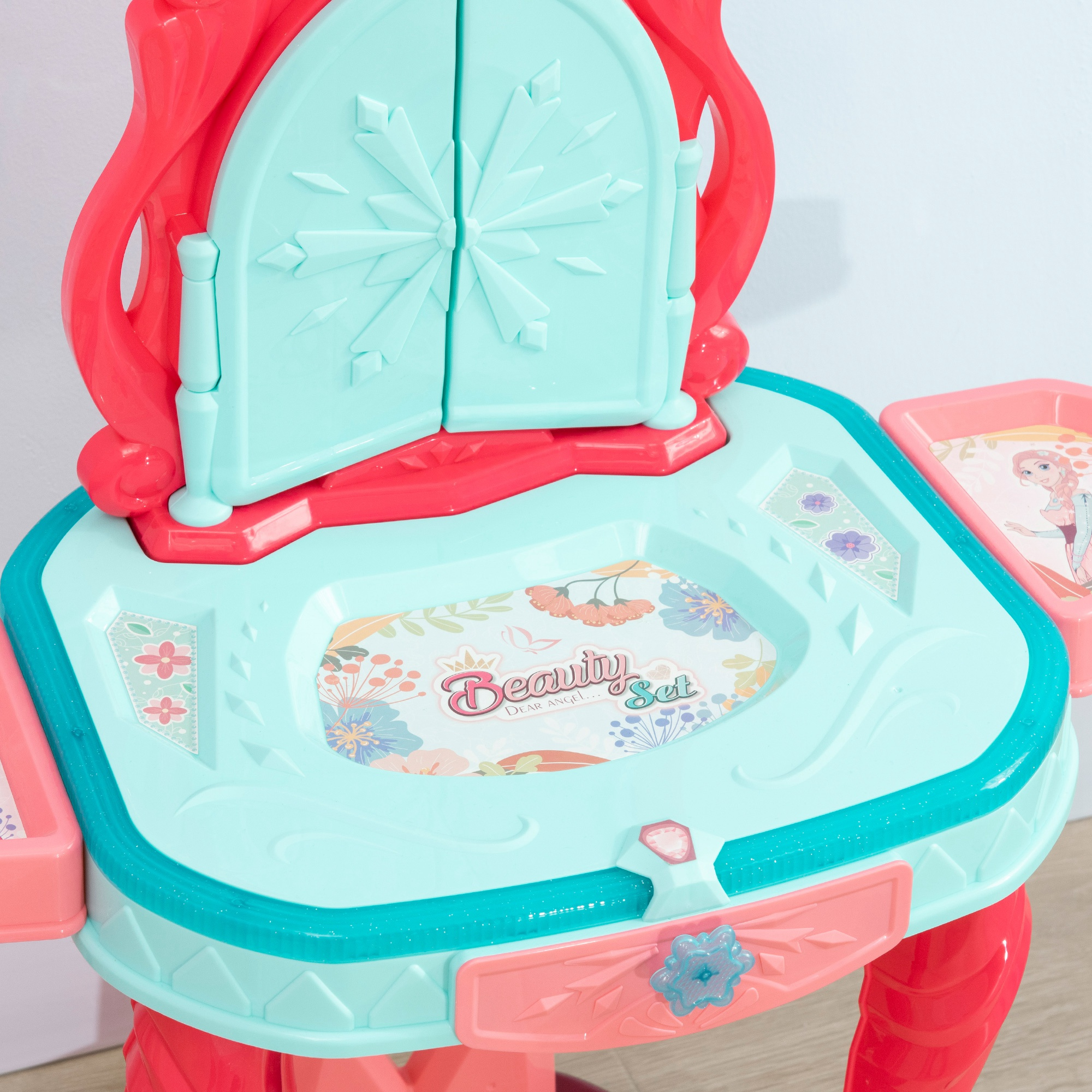 Un set di vanità giocattolo rosa e blu con specchio e cassetti.