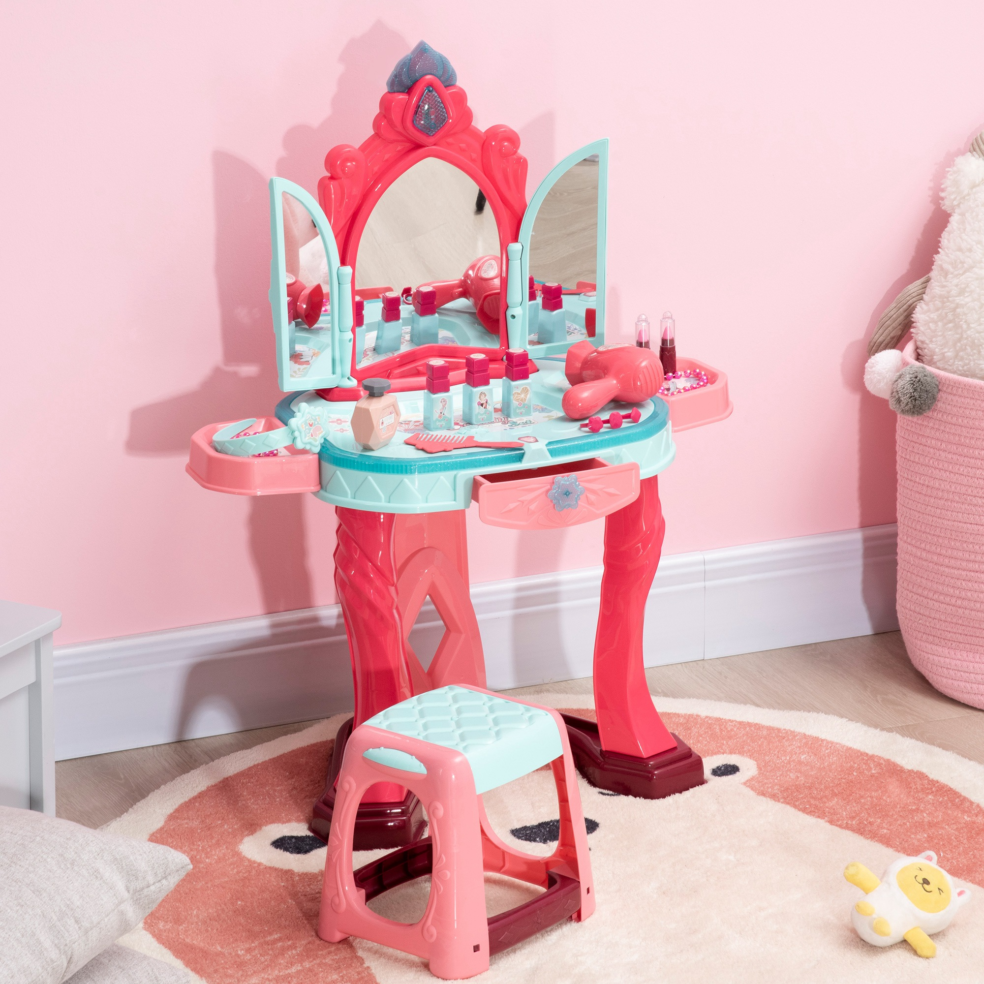Un set da toeletta rosa e blu per bambini con specchio, sgabello e accessori su un tappeto rosa.