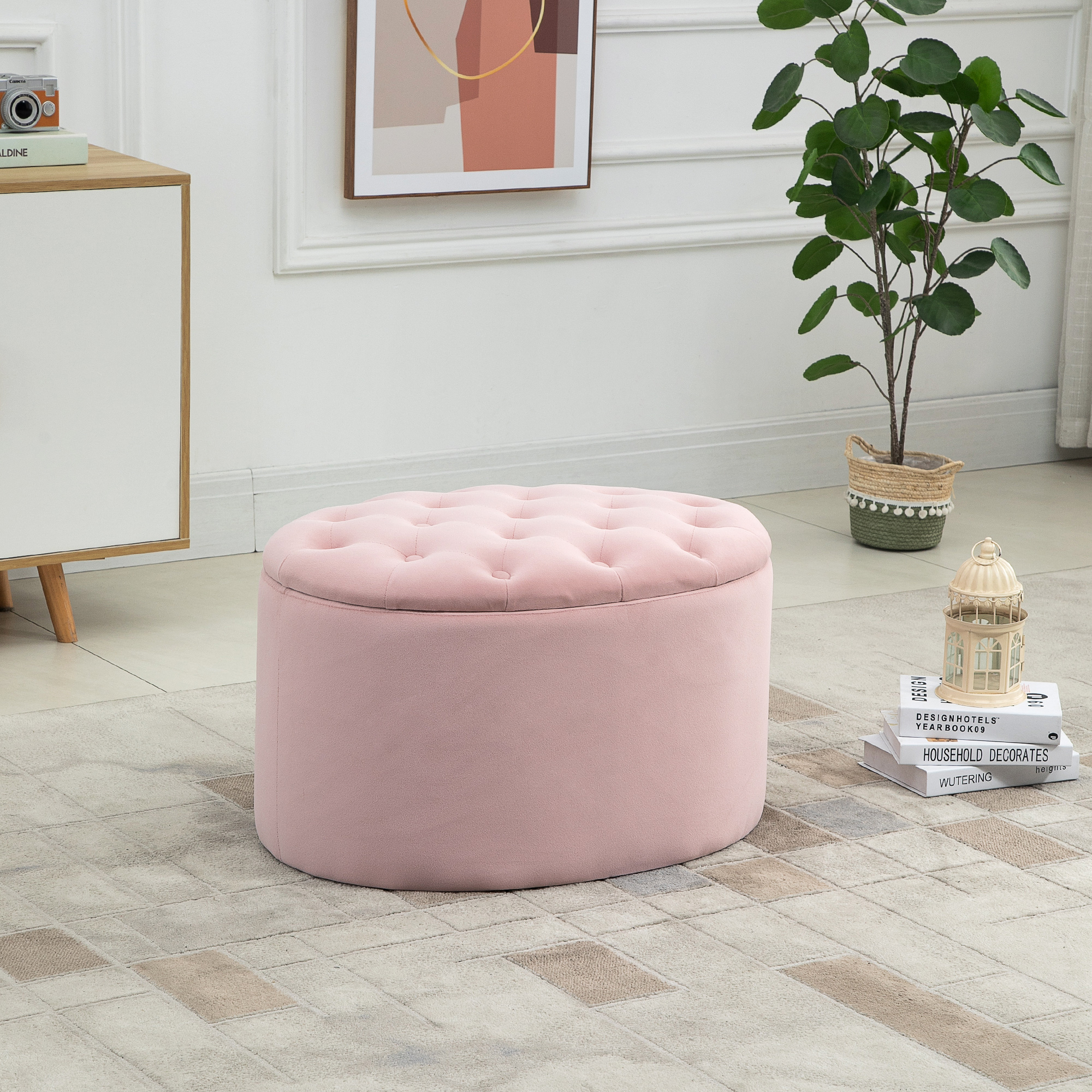 Un pouf rosa con la parte superiore trapuntata. Si trova in una stanza con una pianta, libri e un armadio.