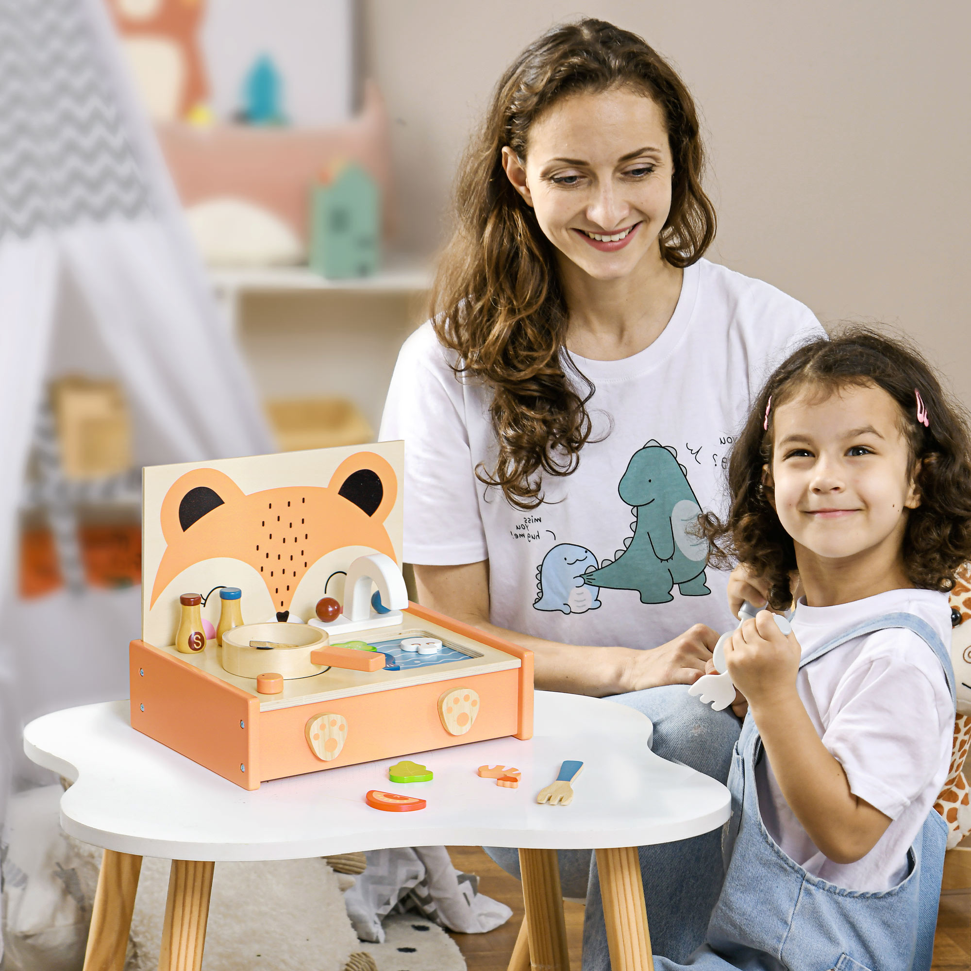 Una donna e una bambina giocano con un giocattolo. Il giocattolo è arancione e ha un design a volpe.