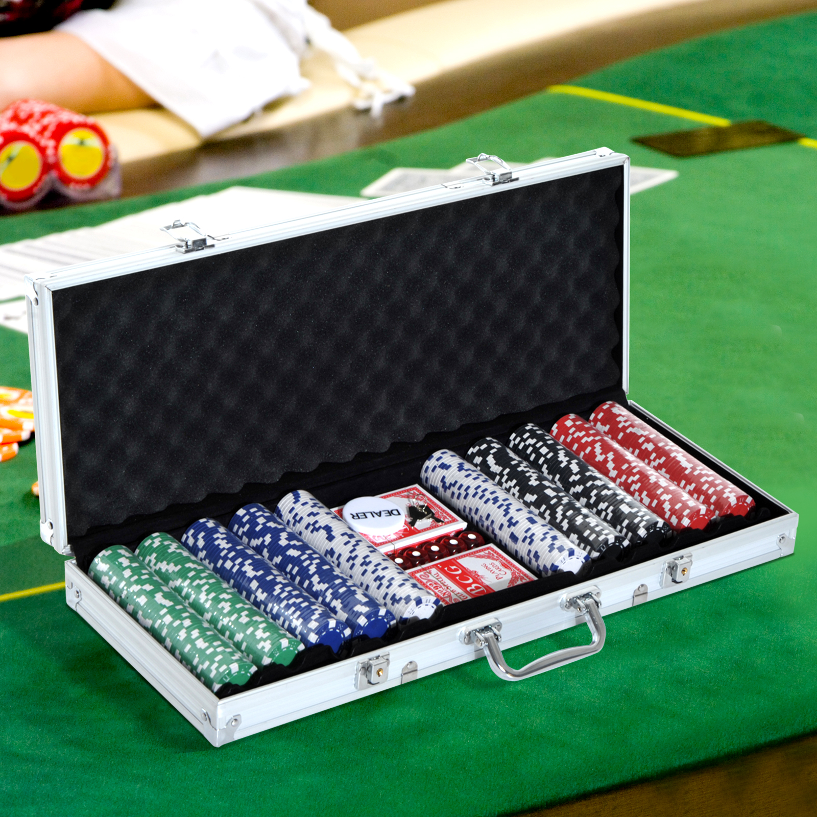 Valigetta d'argento aperta, piena di fiches da poker e carte. Tavolo da poker verde.