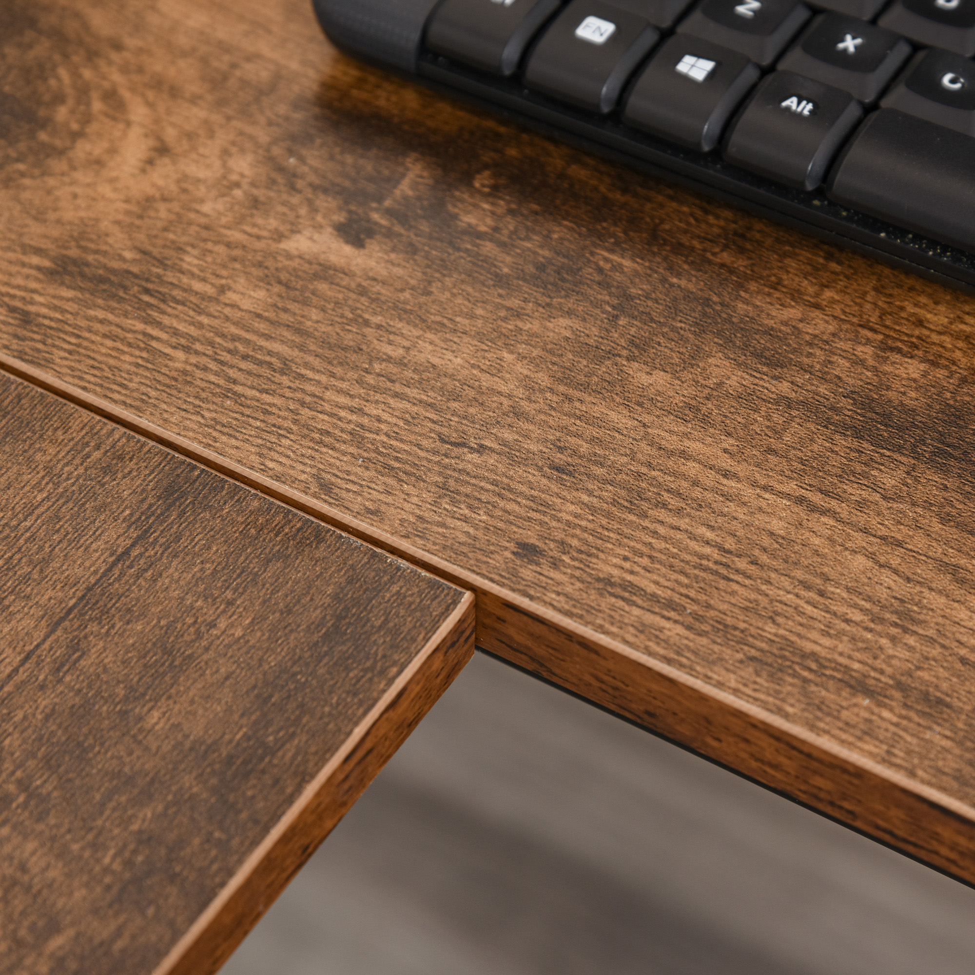 Primo piano di una superficie di scrivania in legno con tastiera.