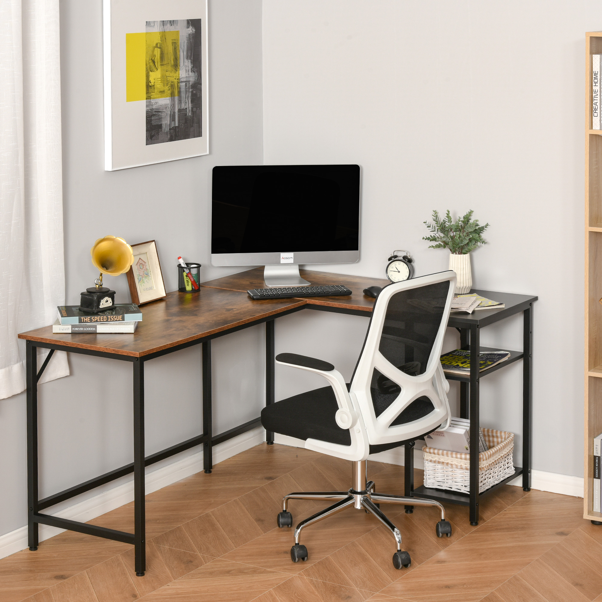 Scrivania a L con computer, sedia e decorazioni. Libri e una lampada sono visibili.