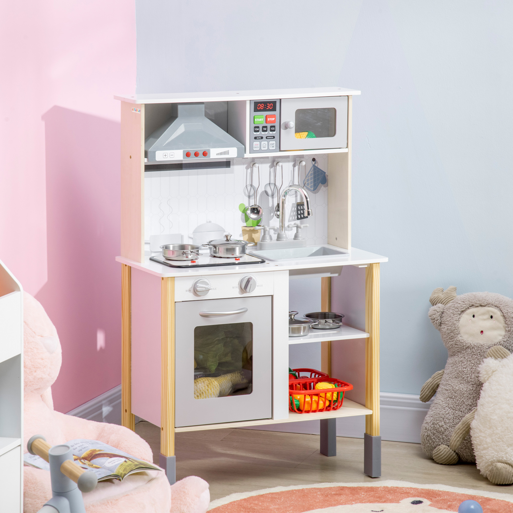Cucina giocattolo con un lato rosa e armadi bianchi. Include microonde, forno, lavandino e accessori.