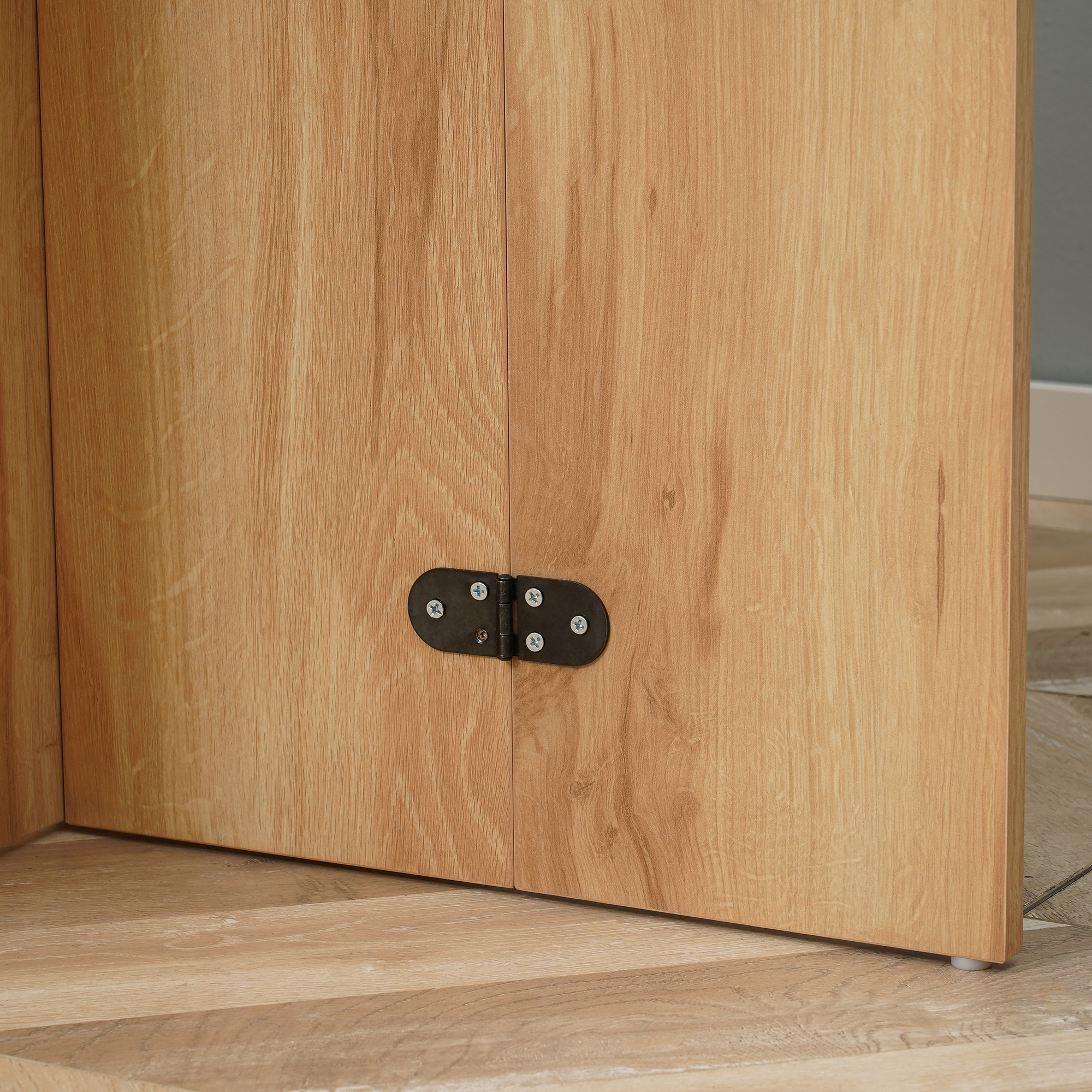 Primo piano di una porta di un mobile in legno e cerniera.