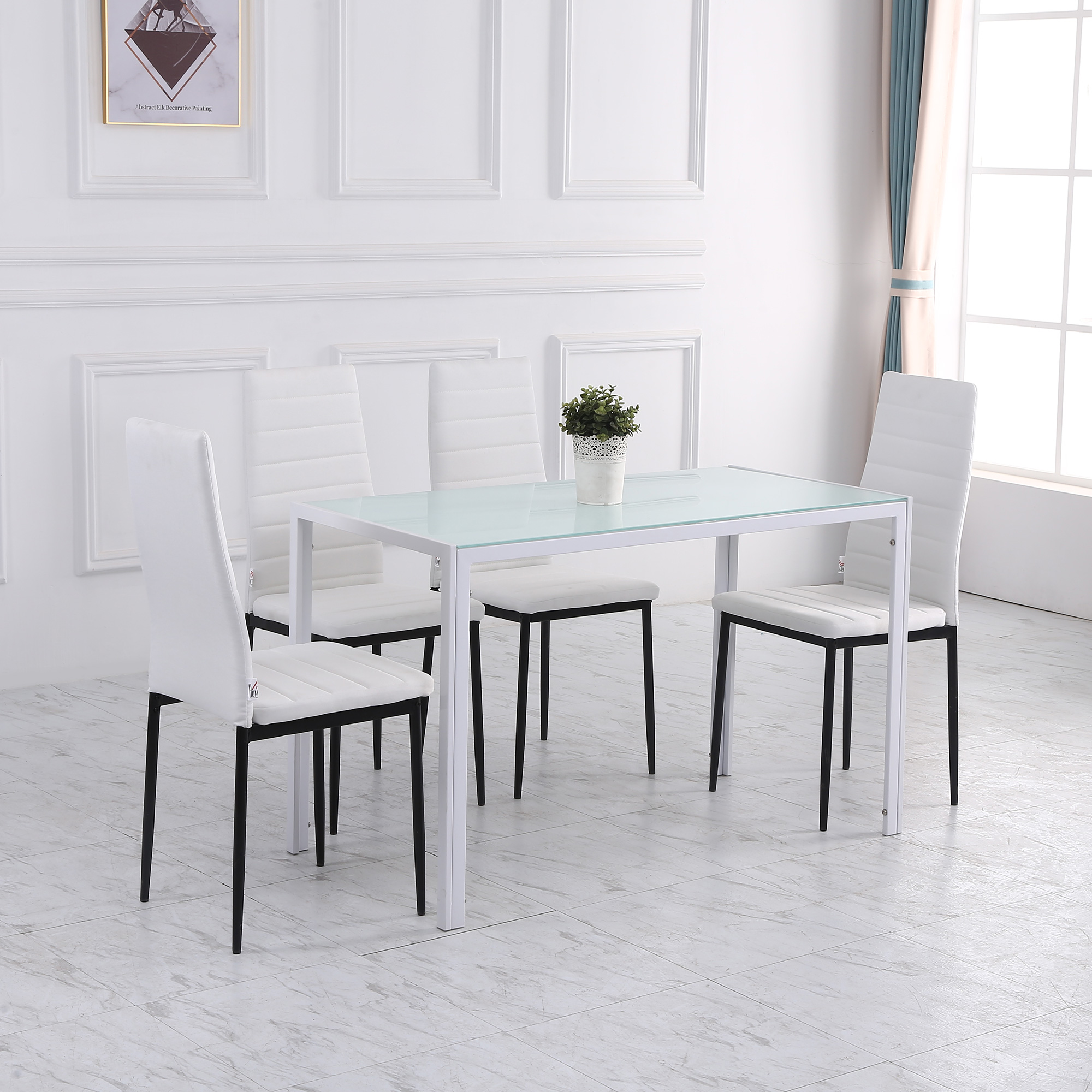 Sala da pranzo con tavolo e sedie bianche.