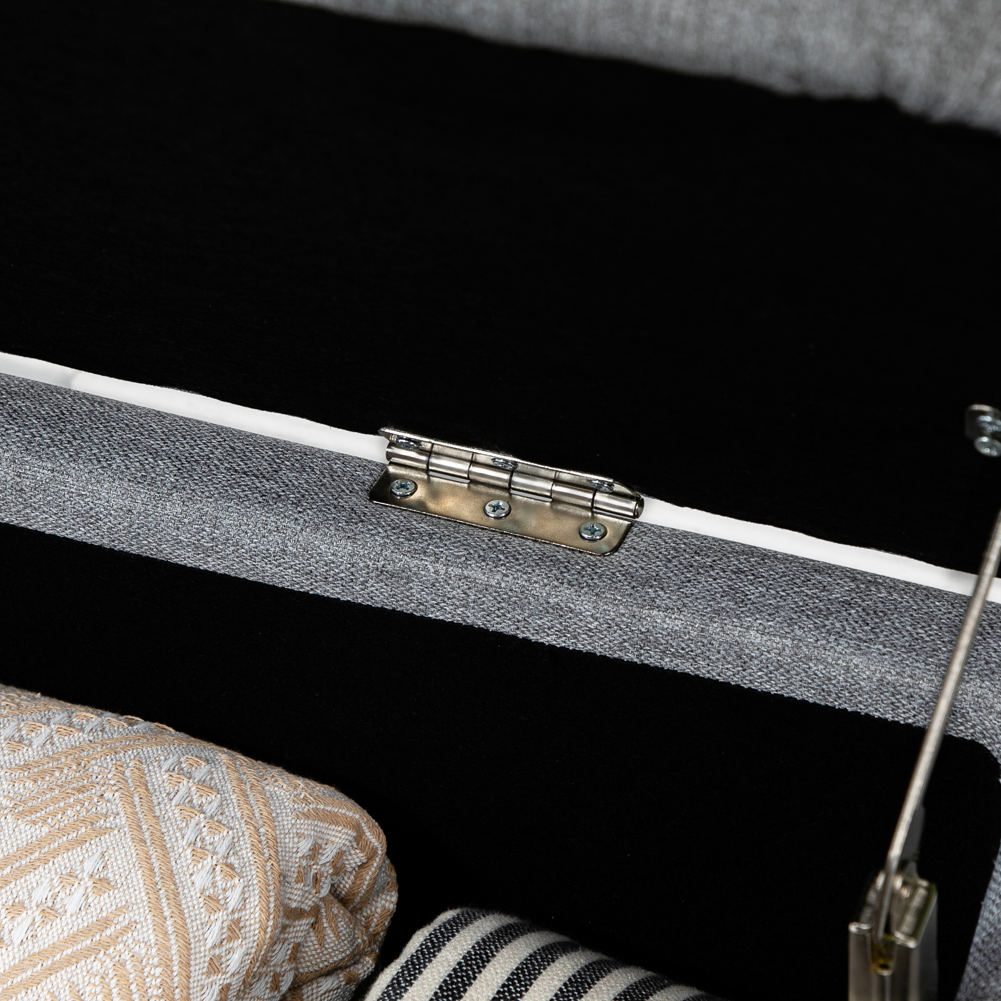 Primo piano dell'interno di un contenitore. Cuscini e coperte piegate sono visibili.