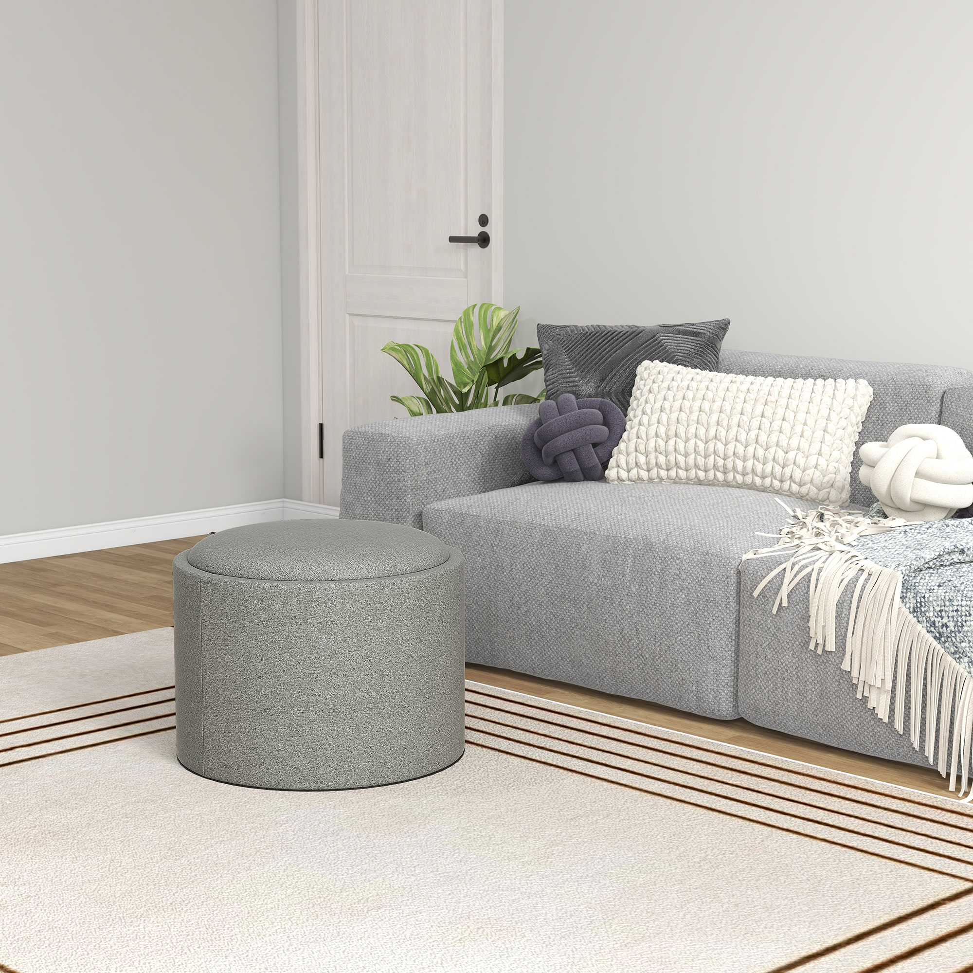 Divano componibile grigio e pouf con cuscini decorativi in una stanza.