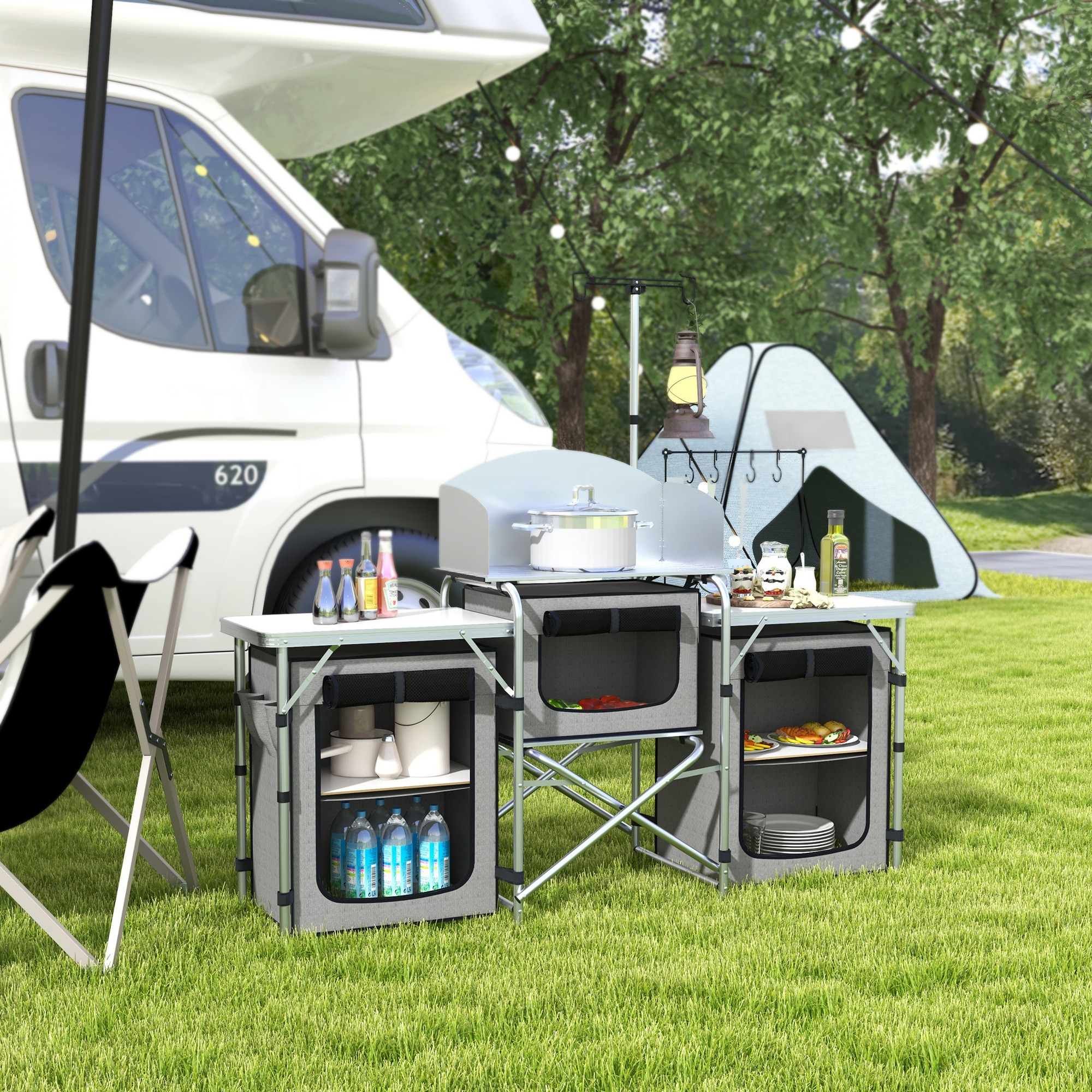 Escena de camping con cocina de camping. Armarios grises, utensilios de cocina, tienda de campaña al fondo, autocaravana.