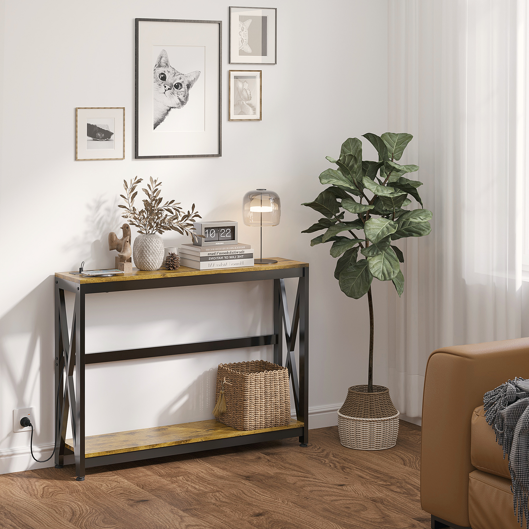 Tavolo consolle con decorazioni. Libri, vaso con rami, lampada e quadri al muro. Pavimento in legno.