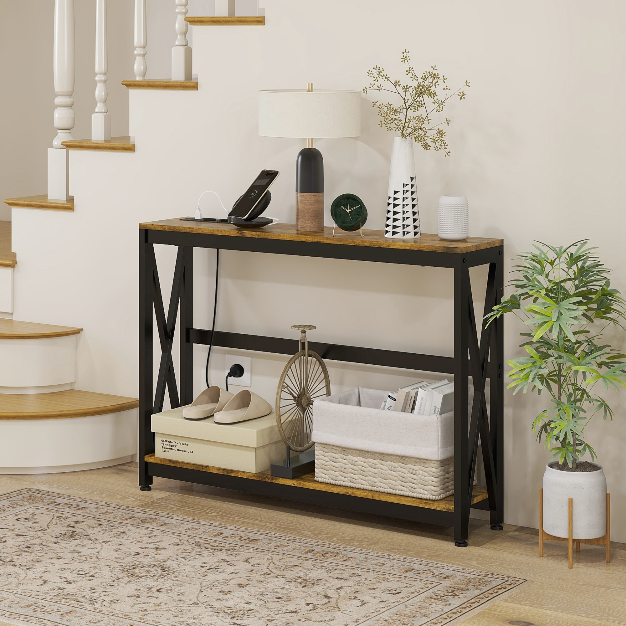 Tavolo d'ingresso con decorazioni, lampada, caricatore, scarpe e pianta, vicino alle scale.
