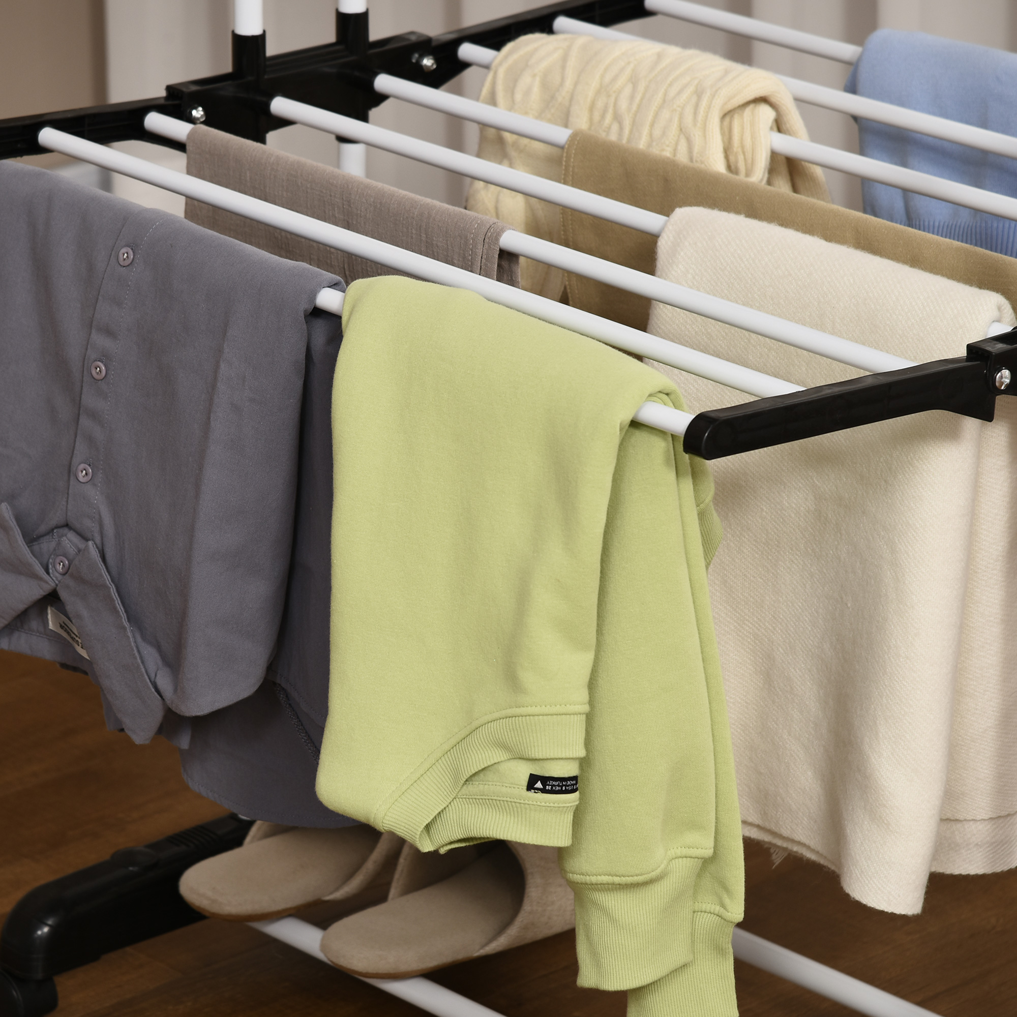 Vestiti appesi a uno stendibiancheria. Sono esposte camicie, pantaloni e maglioni.